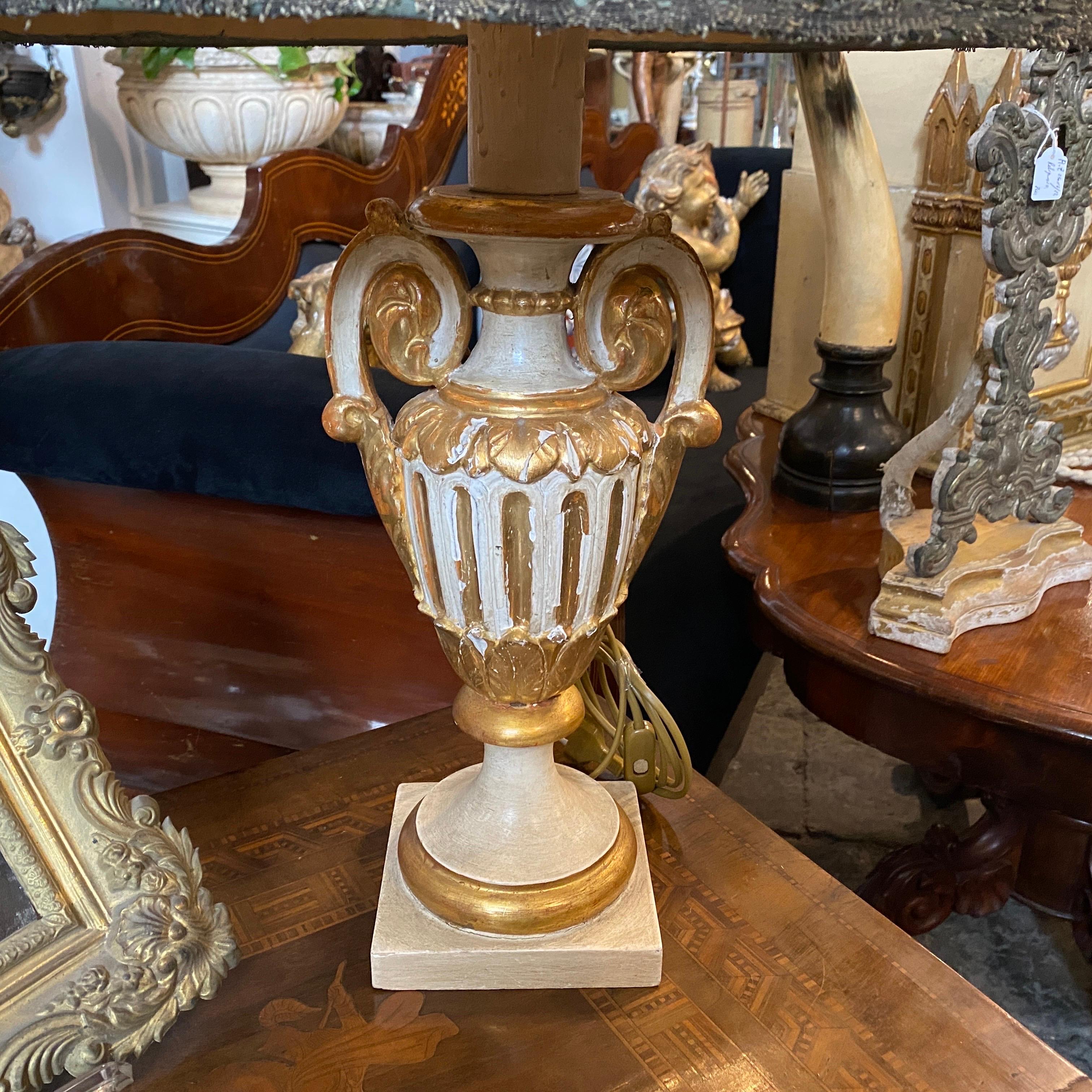 An antique hand-carved, lacquered and gilded wood Sicilian Palm holder, used to decorate antique private church, later it has been transformed in an amazing table lamp, the fabric and silver lampshade it has been totally hand-crafted. We just