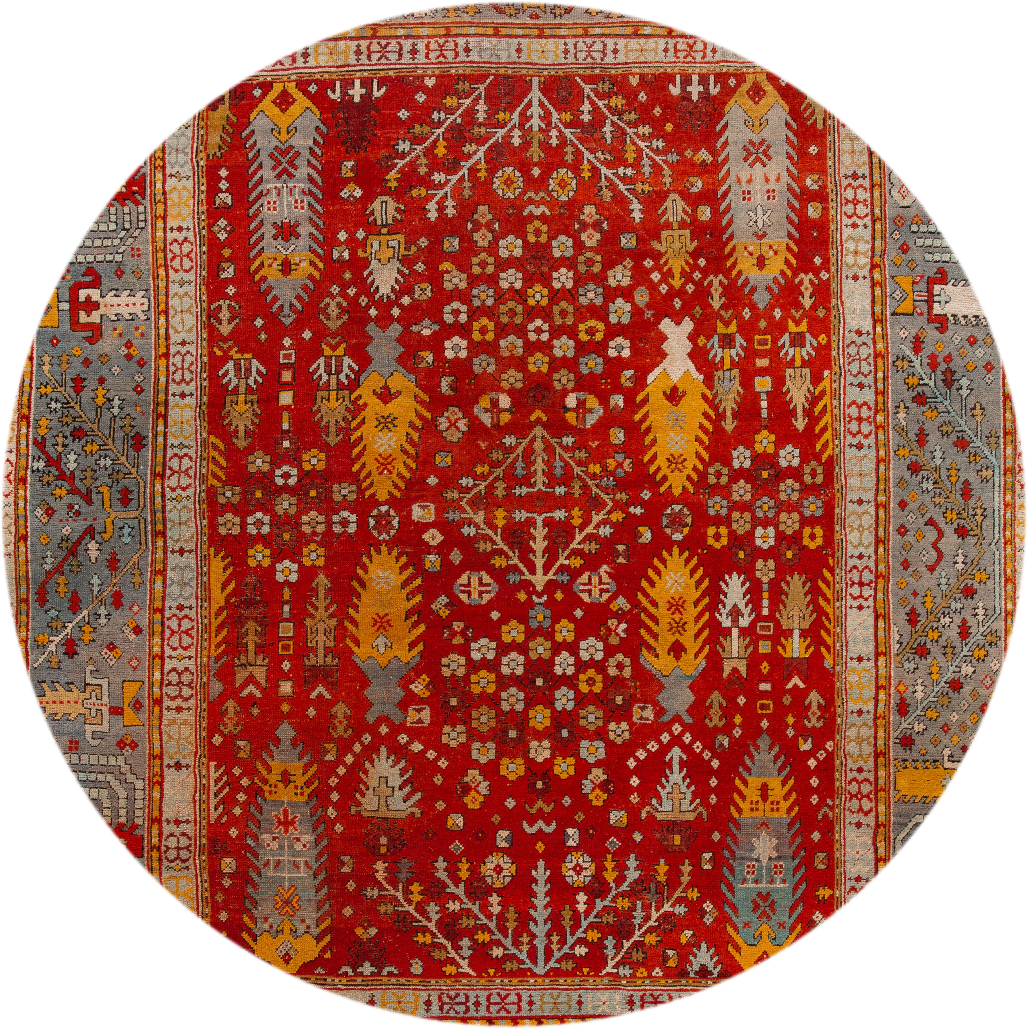 Magnifique tapis turc Oushak ancien, en laine nouée à la main, avec un champ rouge vif, un cadre bleu, des accents bleus et jaunes dans un motif classique sur toute la surface, vers 1890.
Ce tapis mesure 11' 6
