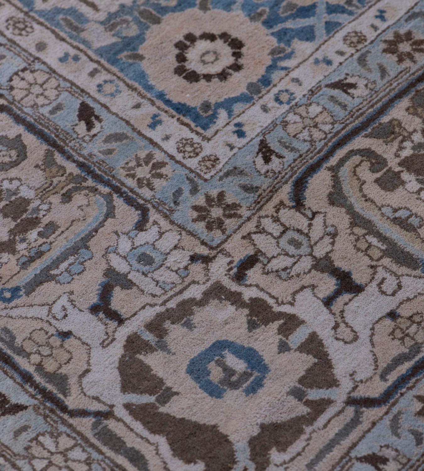 Cet ancien tapis persan Veramin présente un champ bleu ciel avec un motif mina-hani brun chamois et brun chocolat, dans une large bordure brun chamois de vigne florale angulaire à tête de fleur et de palmette entre des bandes de vigne florale ivoire