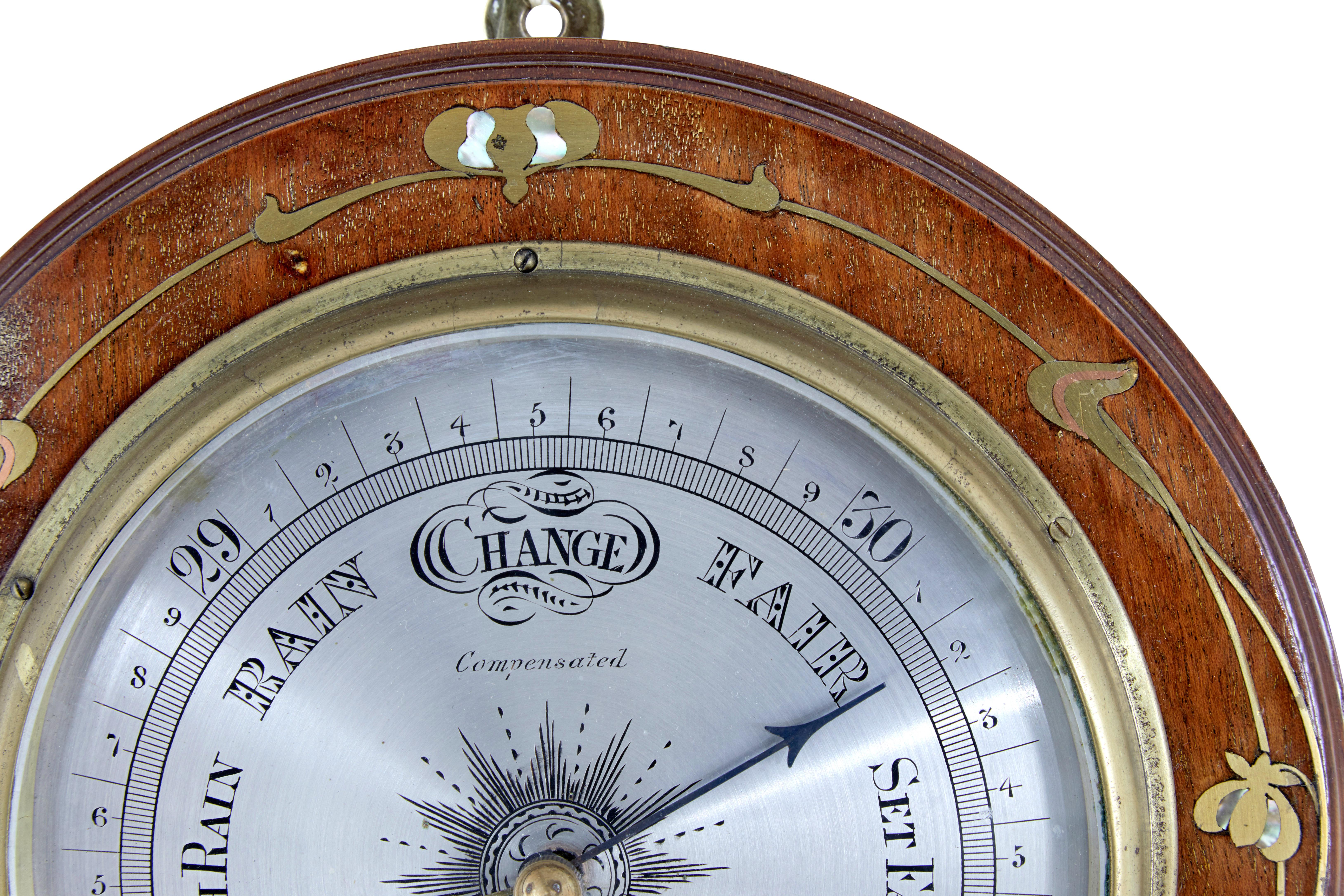 Late 19th century art nouveau barometer circa 1890.

Unusual aneroid barometer, which means it doesn't contain liquid and measures pressure changes by using air to expand its components.

Circular shape, inlaid with brass and mother of pearl. 