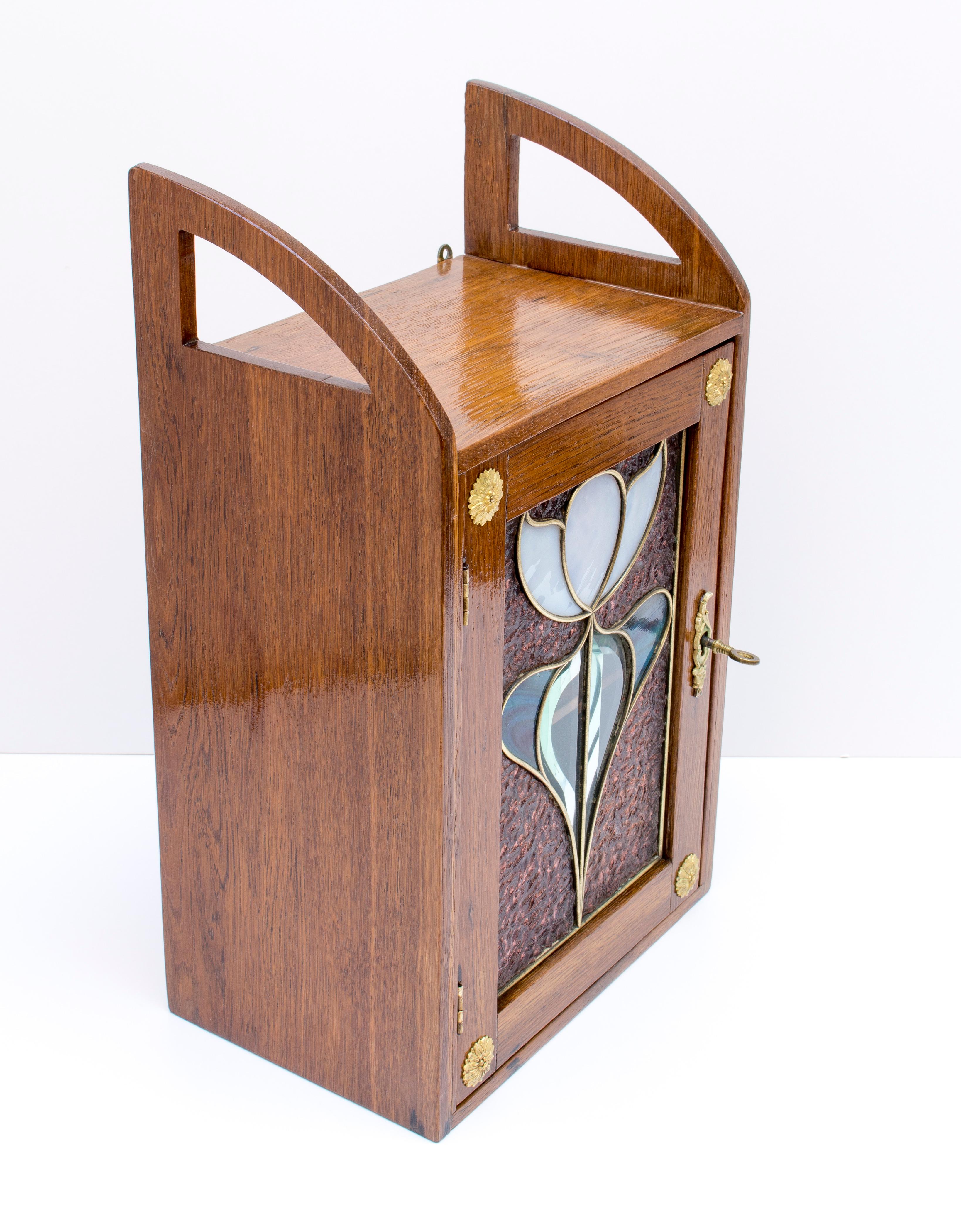 Beautiful hanging wall cabinet from the time of Art Nouveau, circa 1895 made of oak wood made with the original Art Nouveau glass. In very good restored condition.