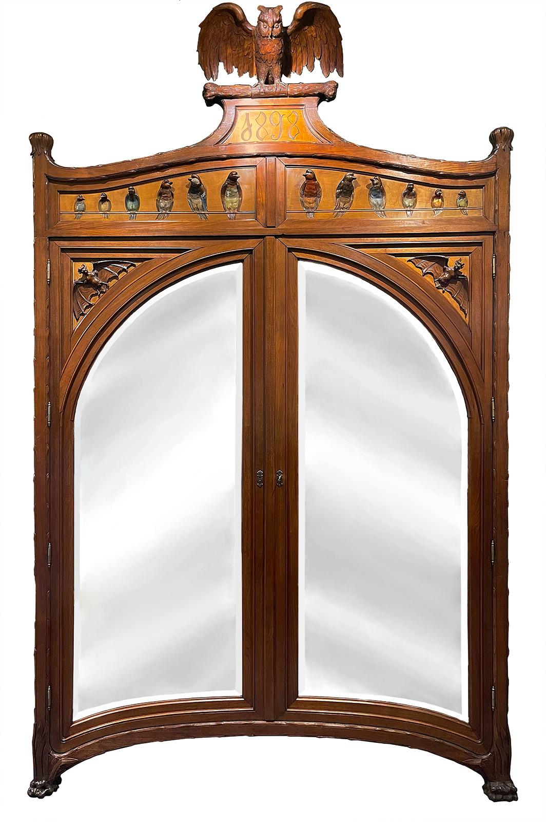 A late 19th century French Art Nouveau bedroom suite with carved owls, bats and birds. Includes a mirrored armoire, full-size bed frame, dressing table, and nightstand. Engraved '1898' at top of armoire. Leather design on bed frame and dressing