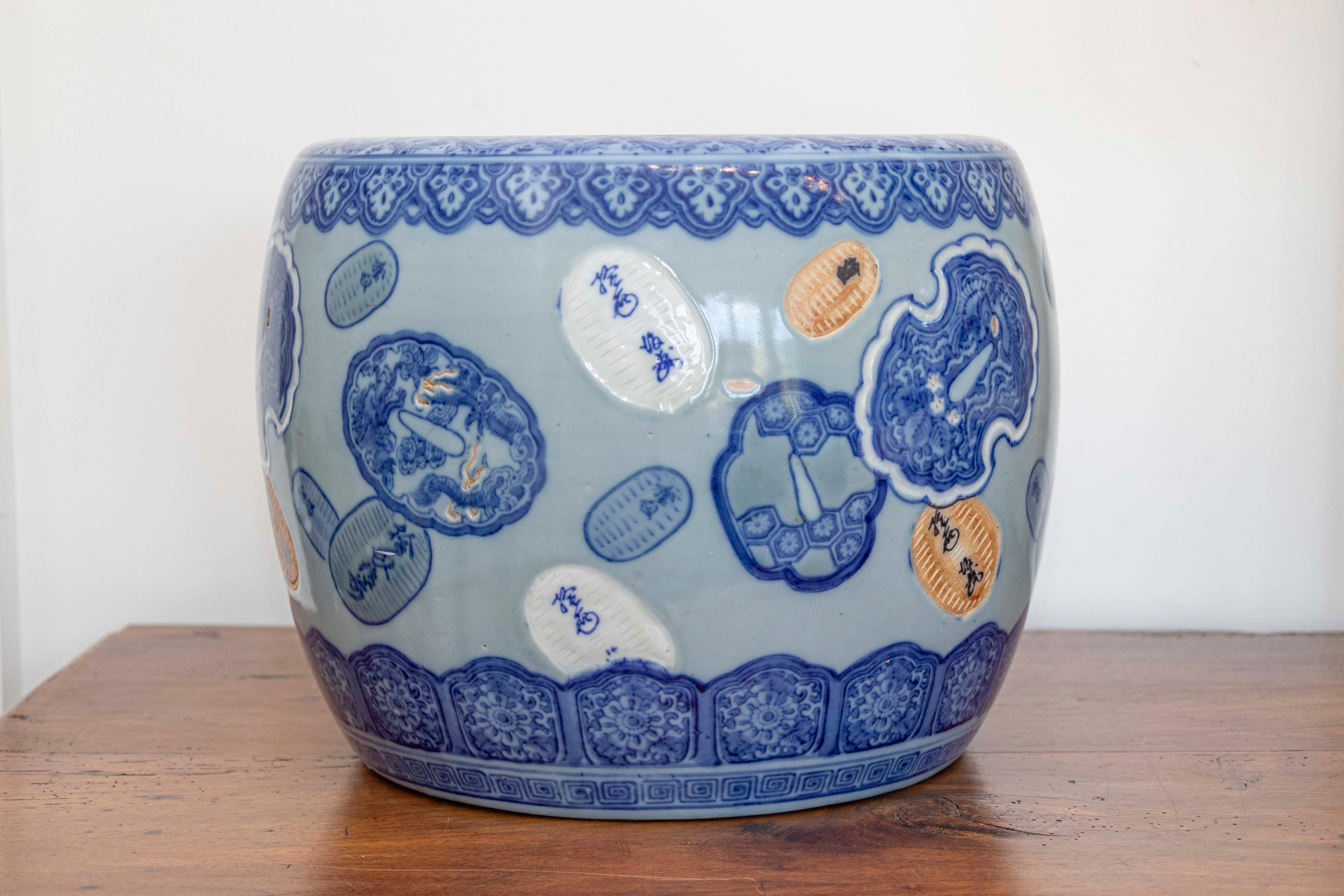 Cache-pot en porcelaine asiatique de la fin du XIXe siècle, avec des cartouches flottants et des tons bleu, blanc et orange. Créé en Asie dans les dernières années du XIXe siècle, ce petit cache-pot nous charme par ses lignes circulaires simples