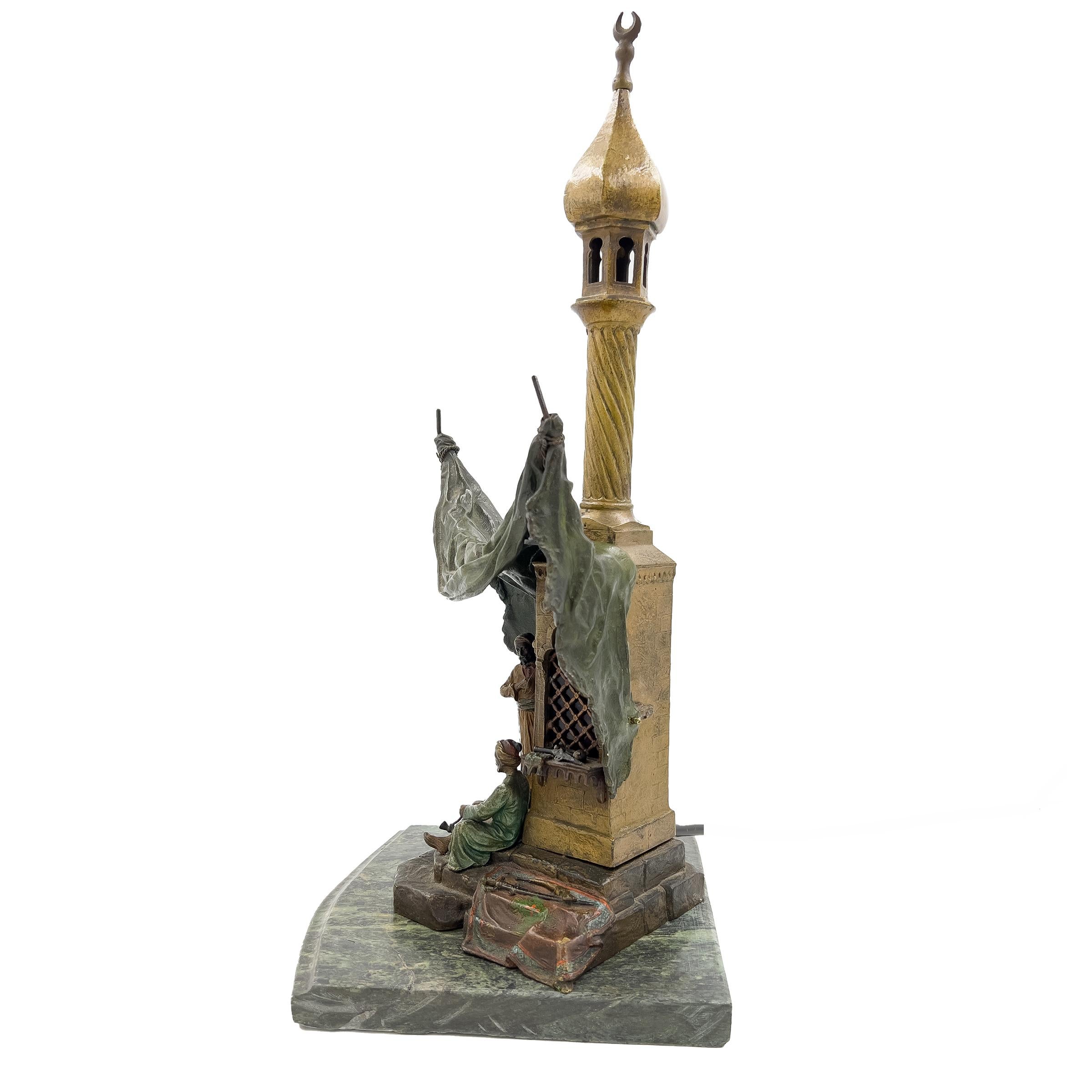 An Austrian cold-painted bronze lamp raised on a green marble base, modelled as a mosque, the stepped base with two figures, stamped to the reverse 'B' within an urn, and with indistinct signature.
 