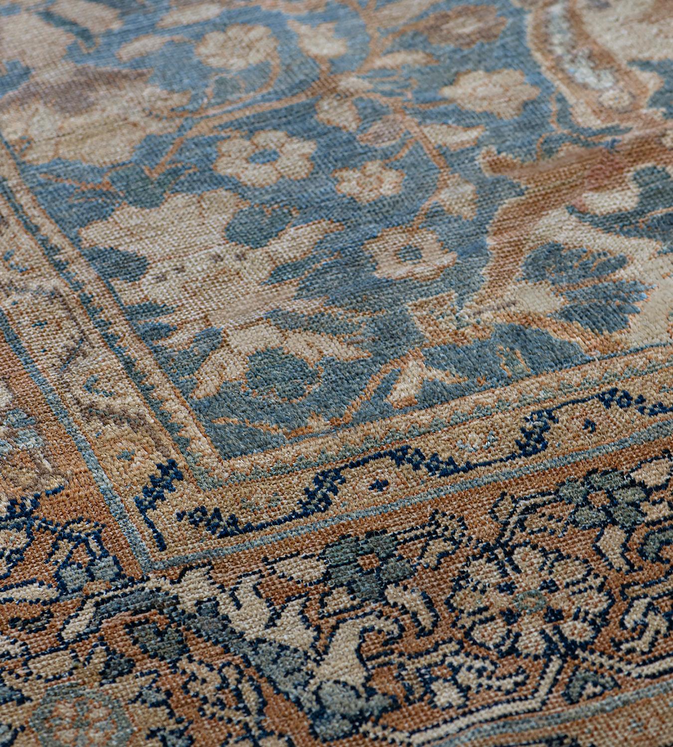 This traditional handwoven Persian Sultanabad rug has a shaded sapphire field with dense scrolling floral vines enclosing parallel cusped lozenge columns, in an elegant apricot palmette vine border, between beige ribbon stripes.
