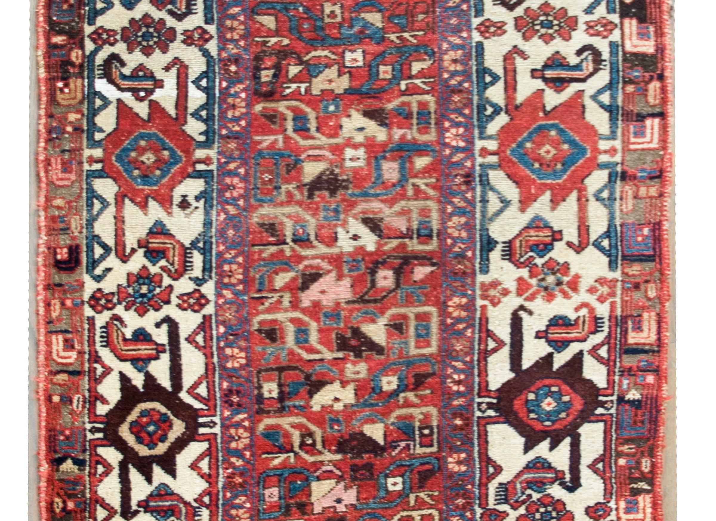 An incredible late 19th century Persian Azari runner with the most wonderful tribal pattern with a central field of all-over stylized flowers and scrolling vines, surrounded by an incredible complex border with more large-scale stylized flowers and