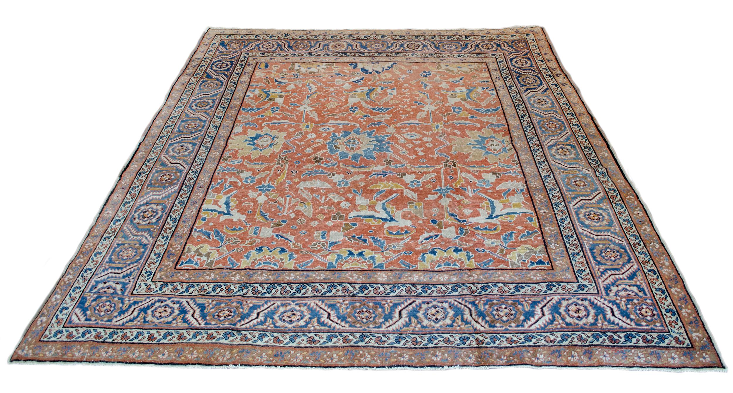 This traditional handwoven Persian Bakhshaish rug has a shaded brick-red field with an overall design of bold polychrome palmettes and tendrils, in a medium-blue border of lush serrated leaves and flowerheads between refined mole-brown and ivory