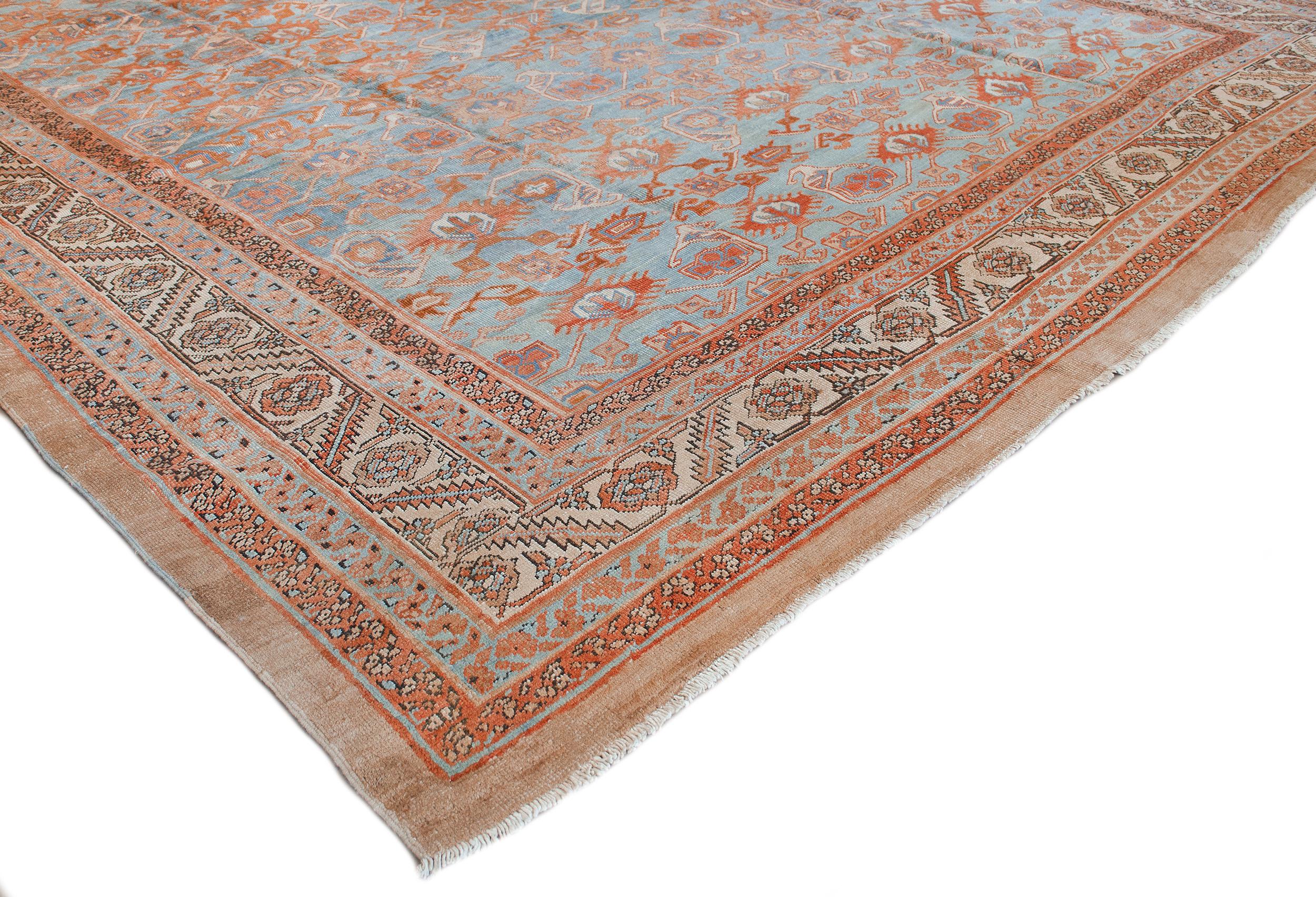 This traditional handwoven Persian Bakhshaish rug has a shaded medium blue field of stylized palmettes issuing angled geometric vines, in an ivory border of rosettes issuing serrated vines, between complementary ornate floral vine stripes, plain