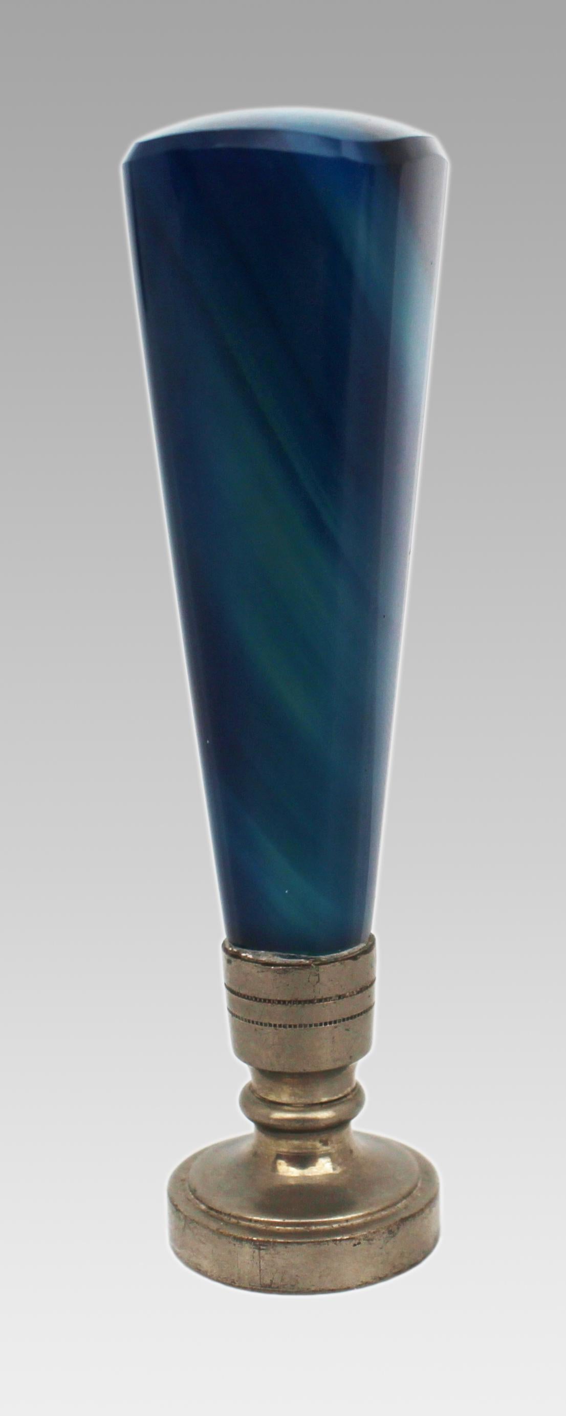 Late 19th Century Banded Agate Wax Seal with Gothic Monogram

A fine antique desk seal dating to the late 19th century. The tapering handle is cut from banded blue agate, exhibiting subtle natural striations and a polished finish. It is mounted on a