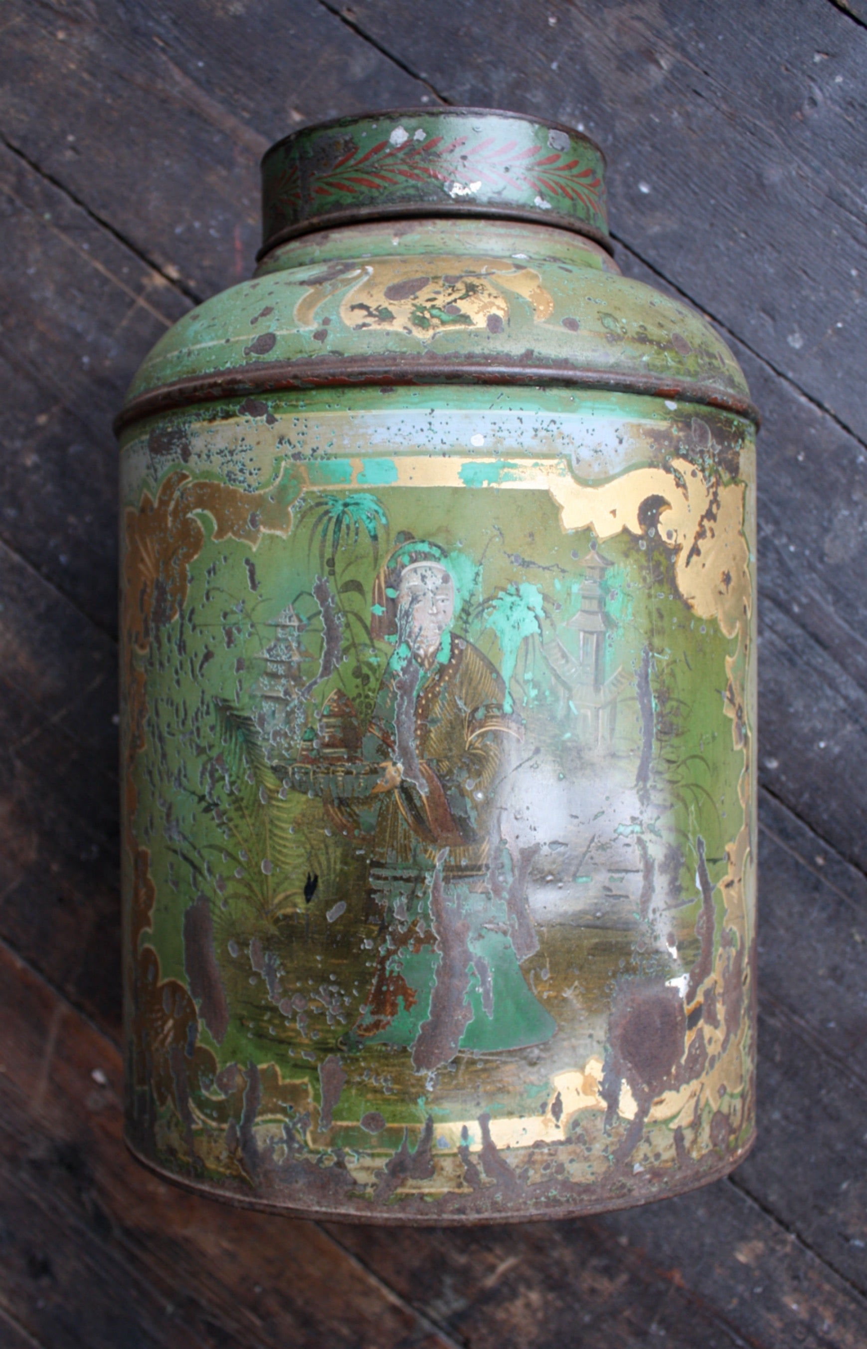 A well executed and large scale English antique Bartlett & Son Japanned tole tea canister

oval cylindrical form with Japanned decoration on a green ground enclosed with gilt decoration, stamped ''Bartlett & Son, Bristol''.

Heavy wear, knocks,