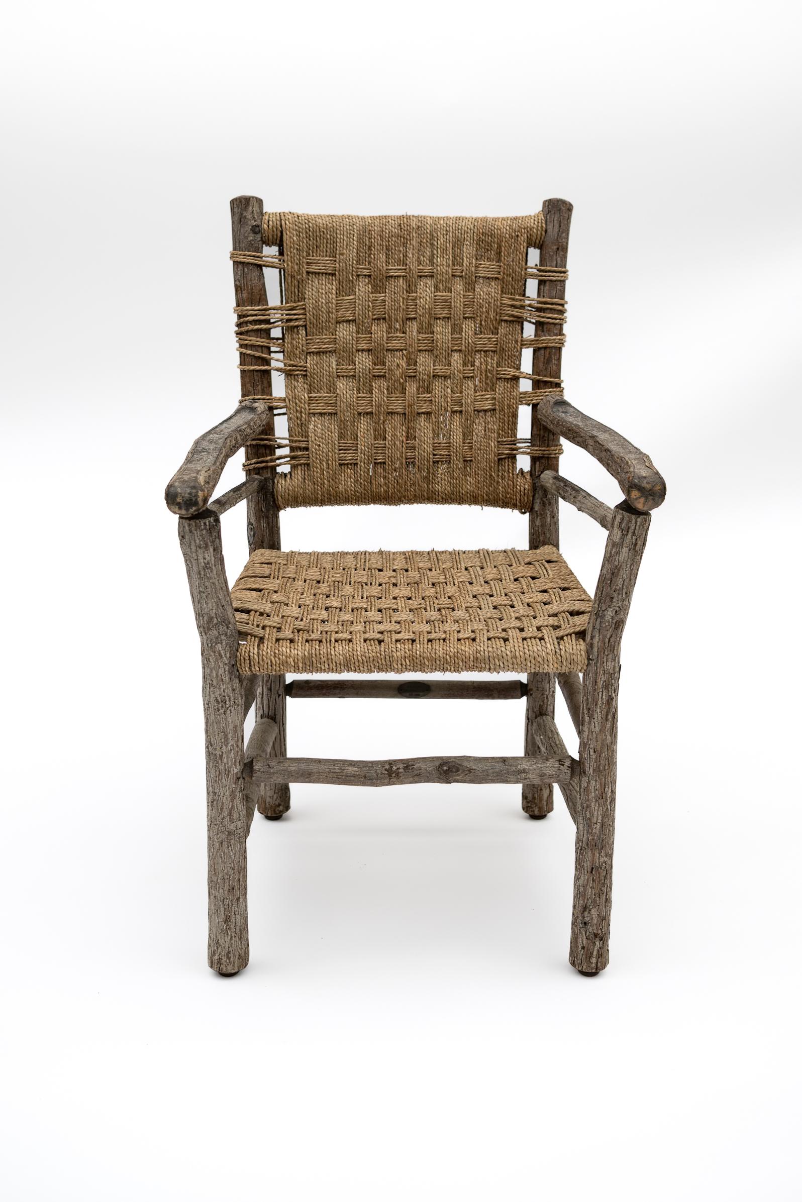 This rustic armchair from Belgium beautifully marries organic materials with timeless craftsmanship. Featuring a sturdy hand-hewn wooden frame with a naturally weathered patina, the chair is accented by a tightly woven seagrass seat and