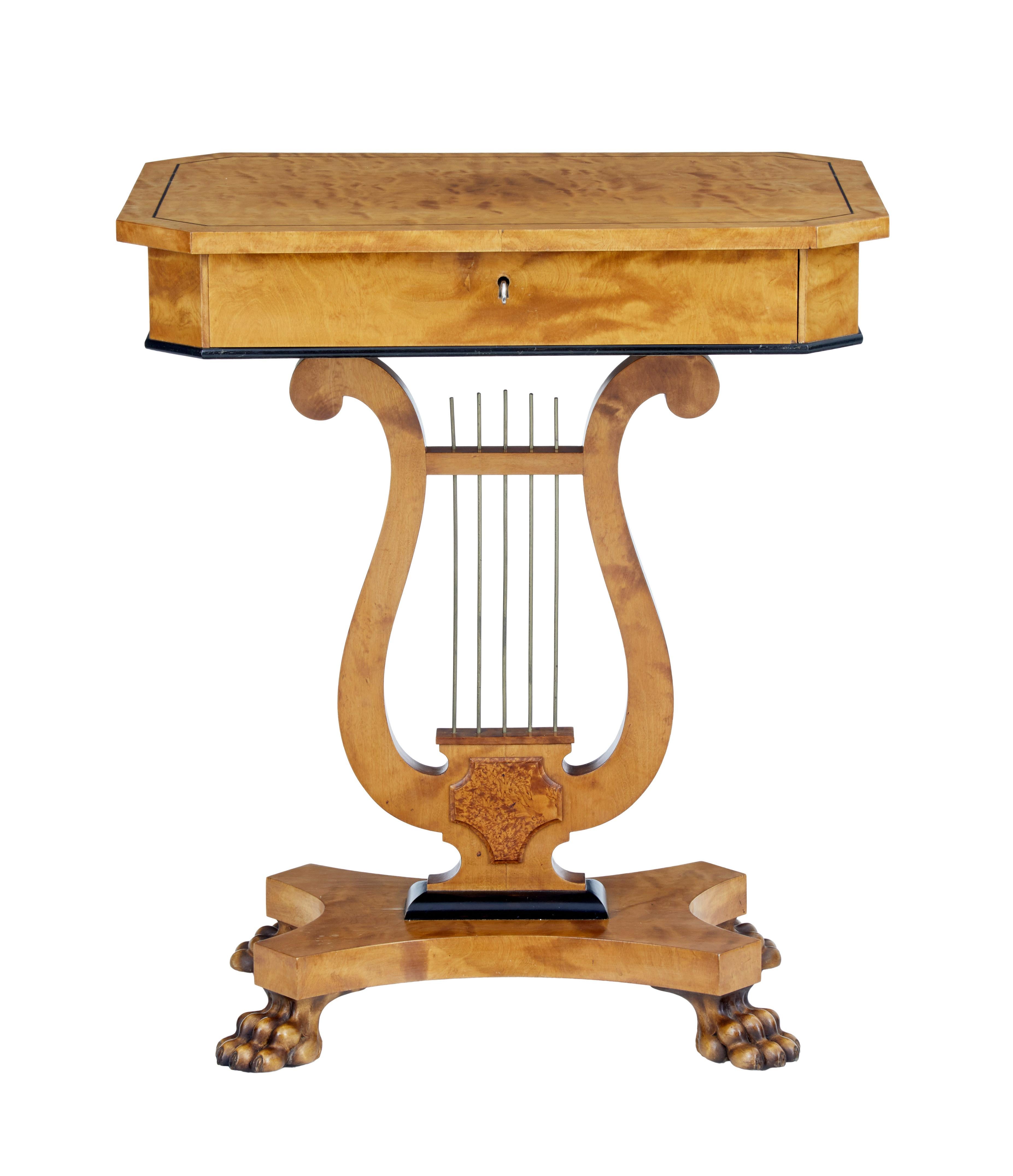 Swedish birch occasional table, circa 1890.

Octagonal top with ebonised stringing. Single drawer fitted with compartments secured with working lock and key. Lyre form base with brass detailing and burr cartouche. Standing on a quadriform base and