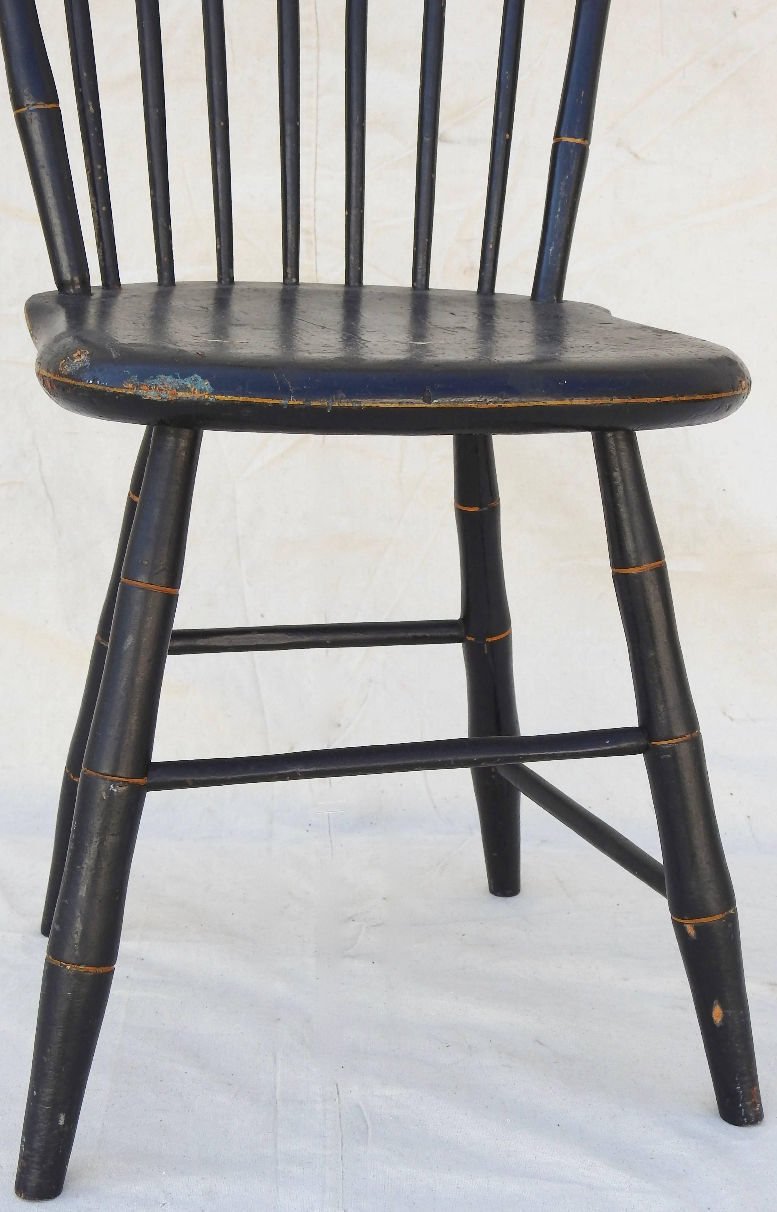 Black with gold detailing stands out on this Windsor chair from the late 19th century. It was made of quality craftsmanship by William Wilt of Prince Edward Island, Canada.. The dents on the seat make you wonder the history surrounding the chair.