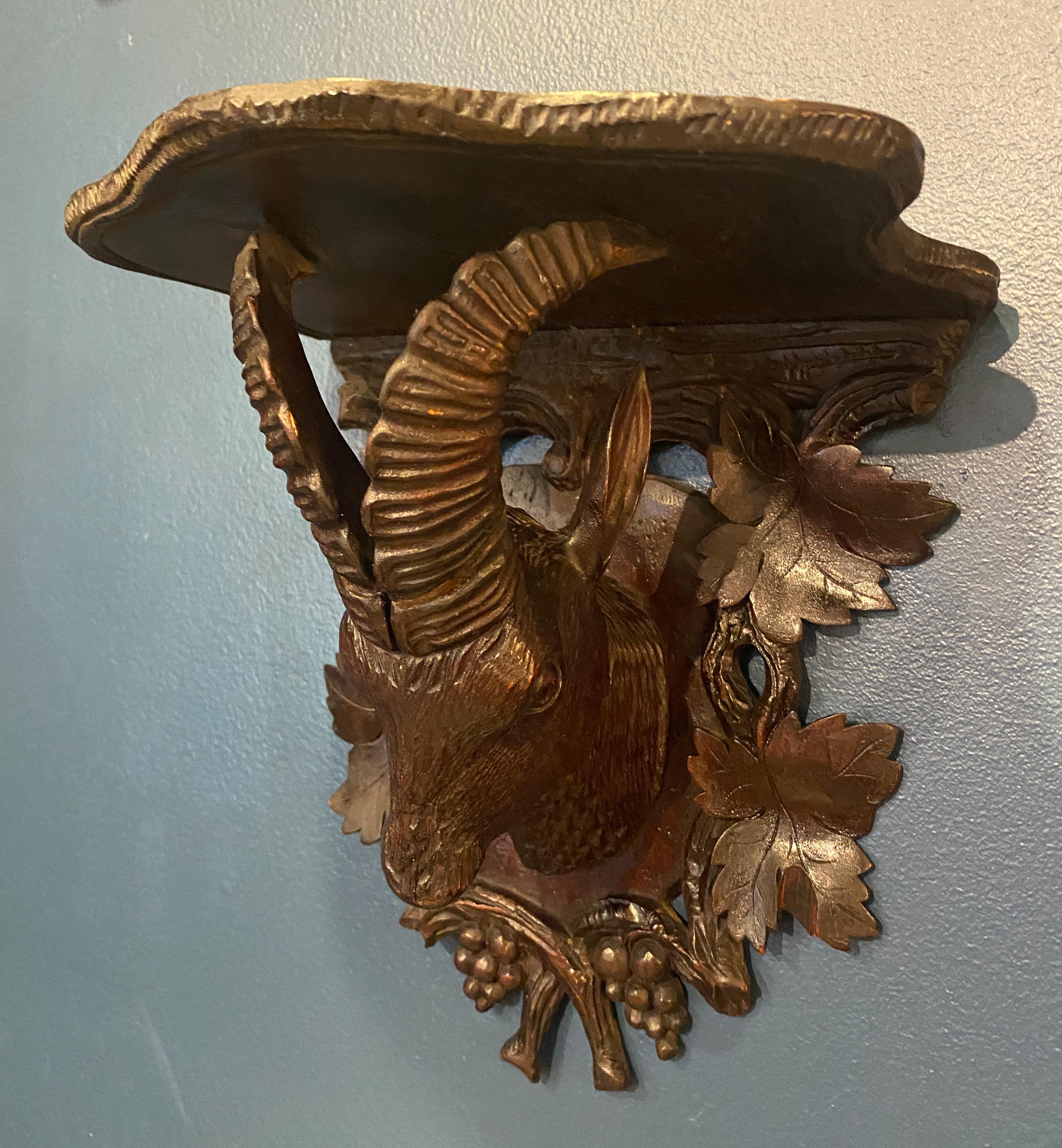 Late 19th century Black Forest ram head with leaf motif wood shelf
Switzerland, circa 1870s 
Good Condition. Hand carved.
Measures: 9.5” H, 9” W, 9.5