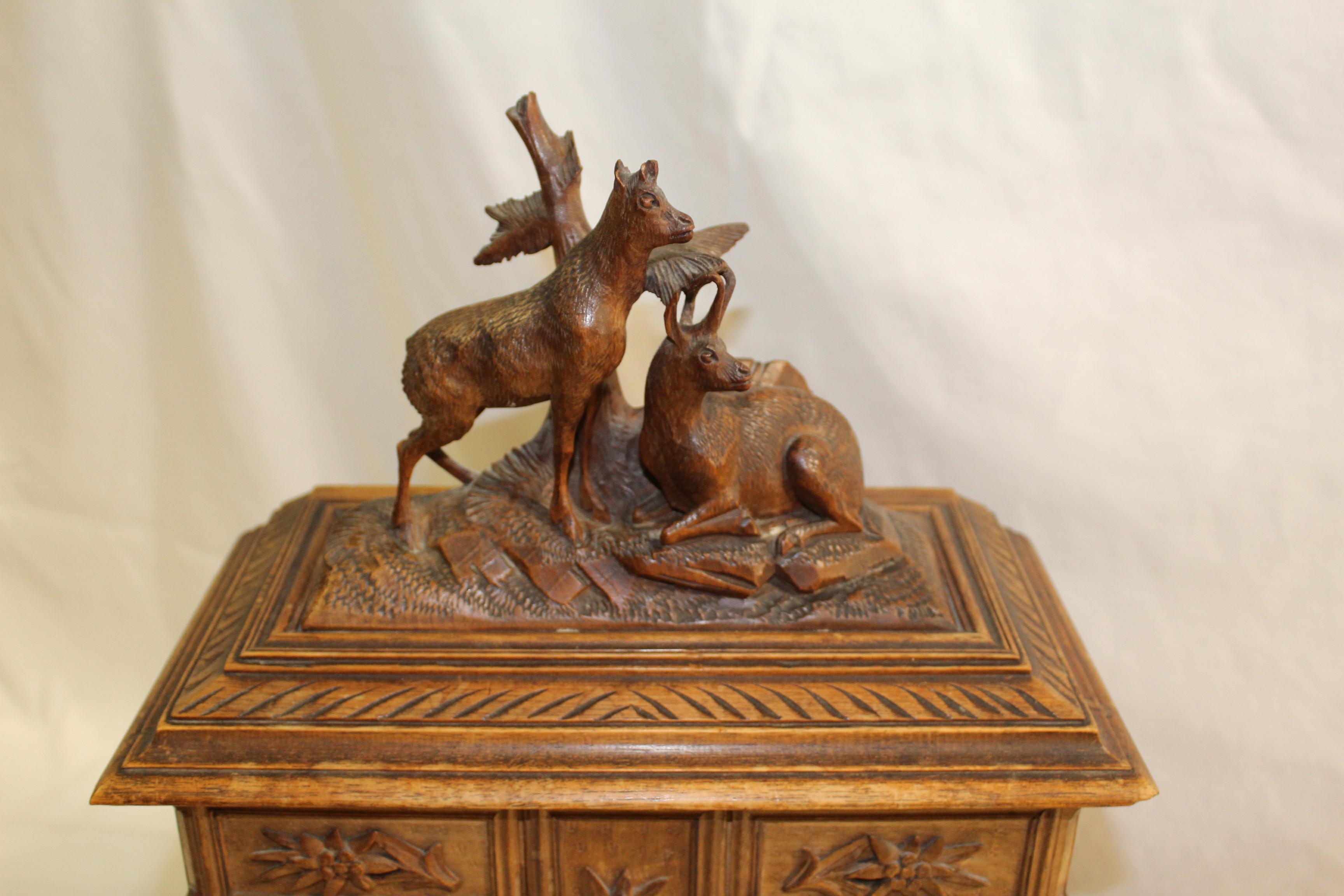 A very finely hand carved Jewelry Cabinet . Has 6 small drawers that swing out for access to the bottom box .  The top flips open and has two carved animals on the top . This has been in a privet collection from a local Antique dealer here . Has