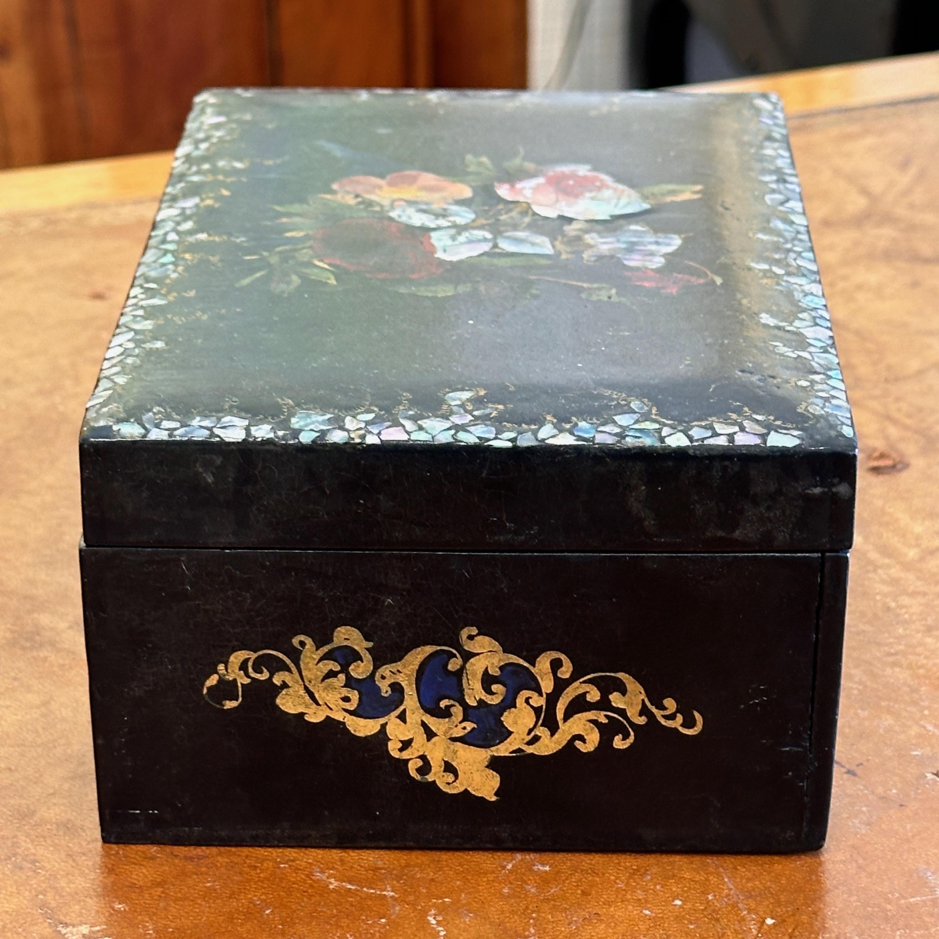 Una scatola laccata nera con decorazioni a intarsio.