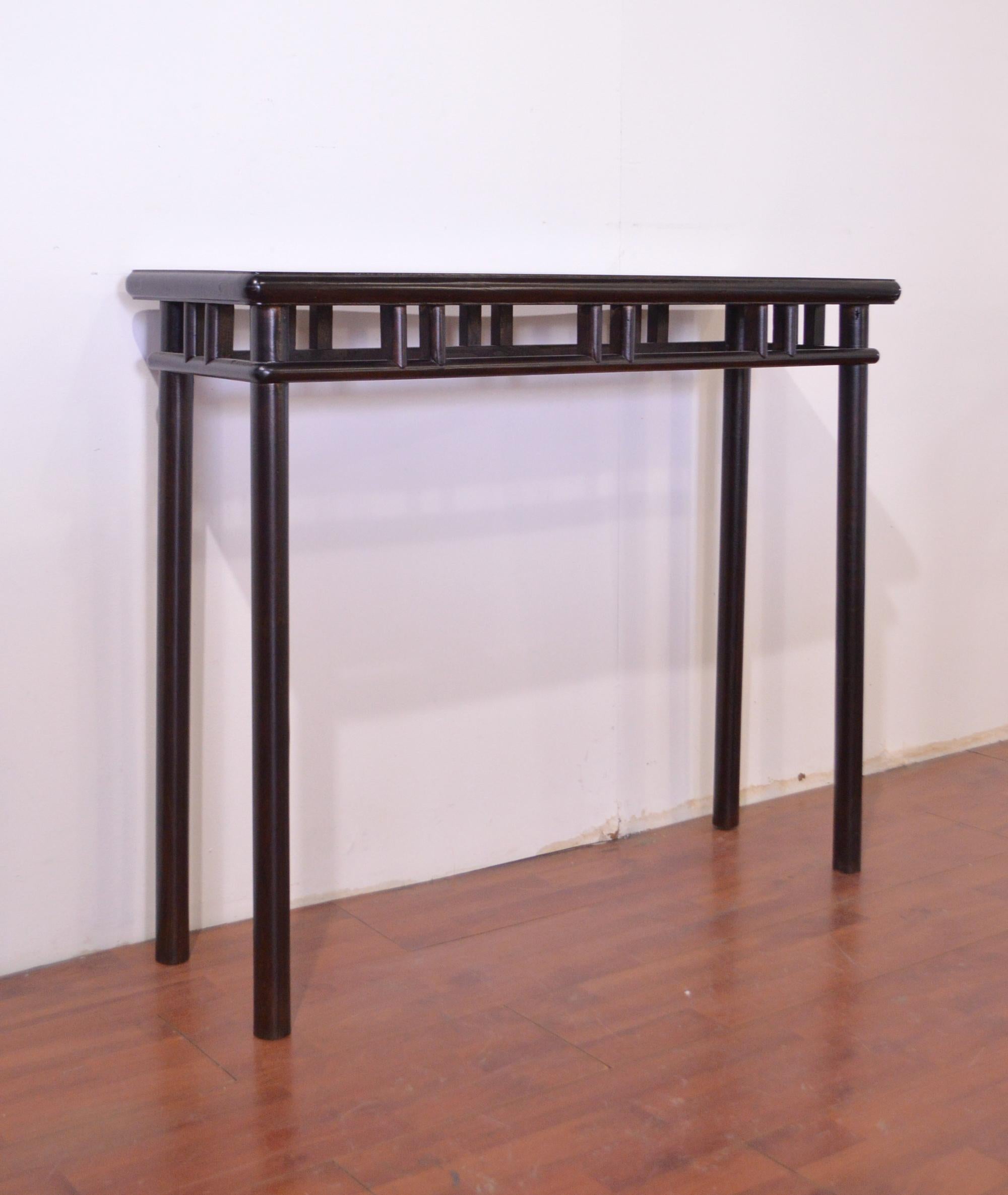 This late 19th century black lacquered consolle in elm wood is definetely a versatile and necessary element. Used as a side table, it was constructed with the round legs found in much of the furniture from the Shandong province; the top is a panel