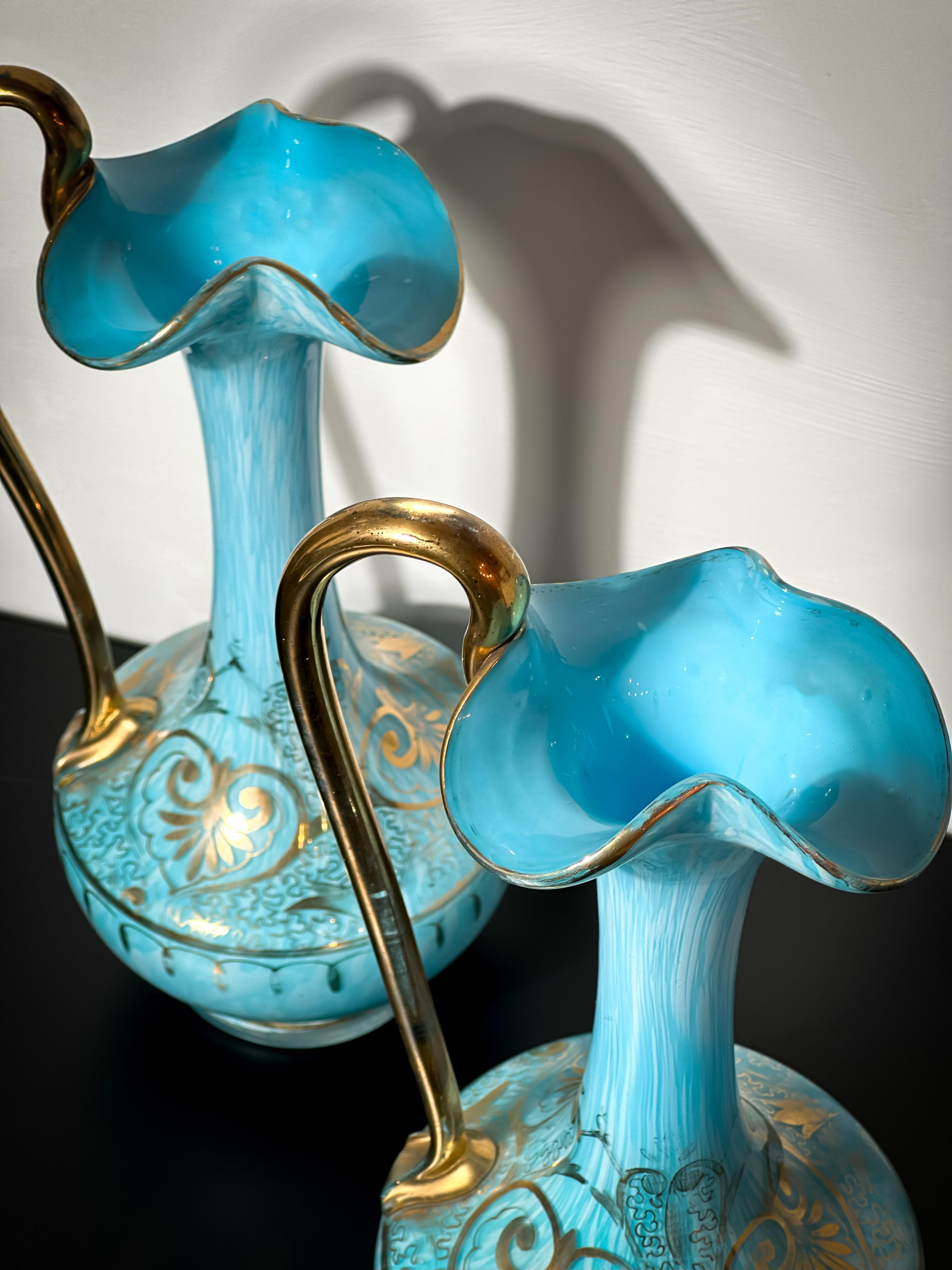 Paire d'aiguières en verre de Bohème ou tchèque de la fin du XIXe siècle, fabriquées à partir de verre opalin bleu pâle marbré et entourées de verre transparent. 

Chaque aiguière se caractérise par une base large et arrondie, se rétrécissant en un