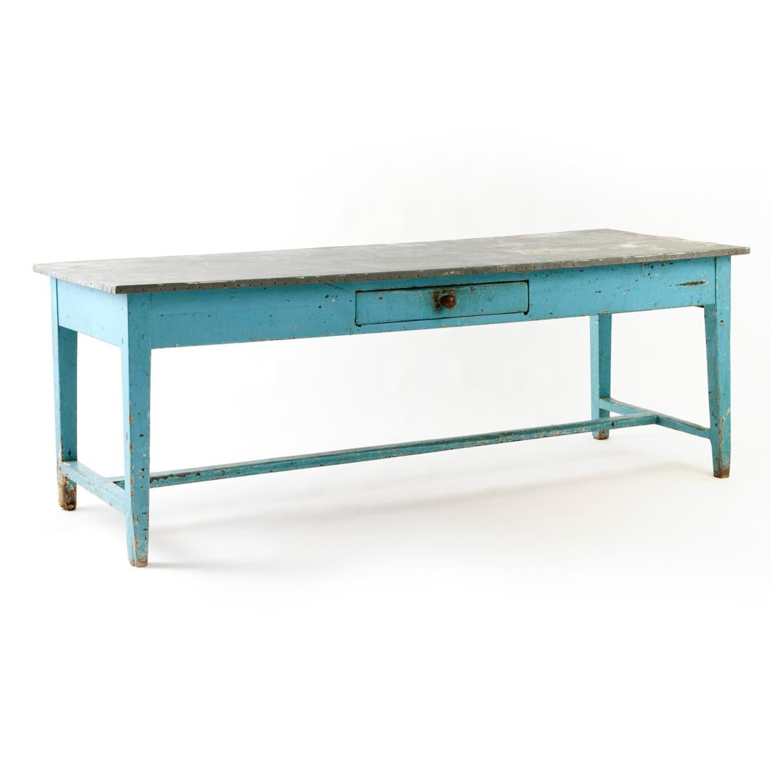 - On craque pour la teinte bleue tant convoitée de cette table de ferme ancienne, dotée d'une peinture et de finitions patinées d'origine.

- D'une forme substantielle avec un seul tiroir et un plateau en zinc original, cette pièce est une merveille