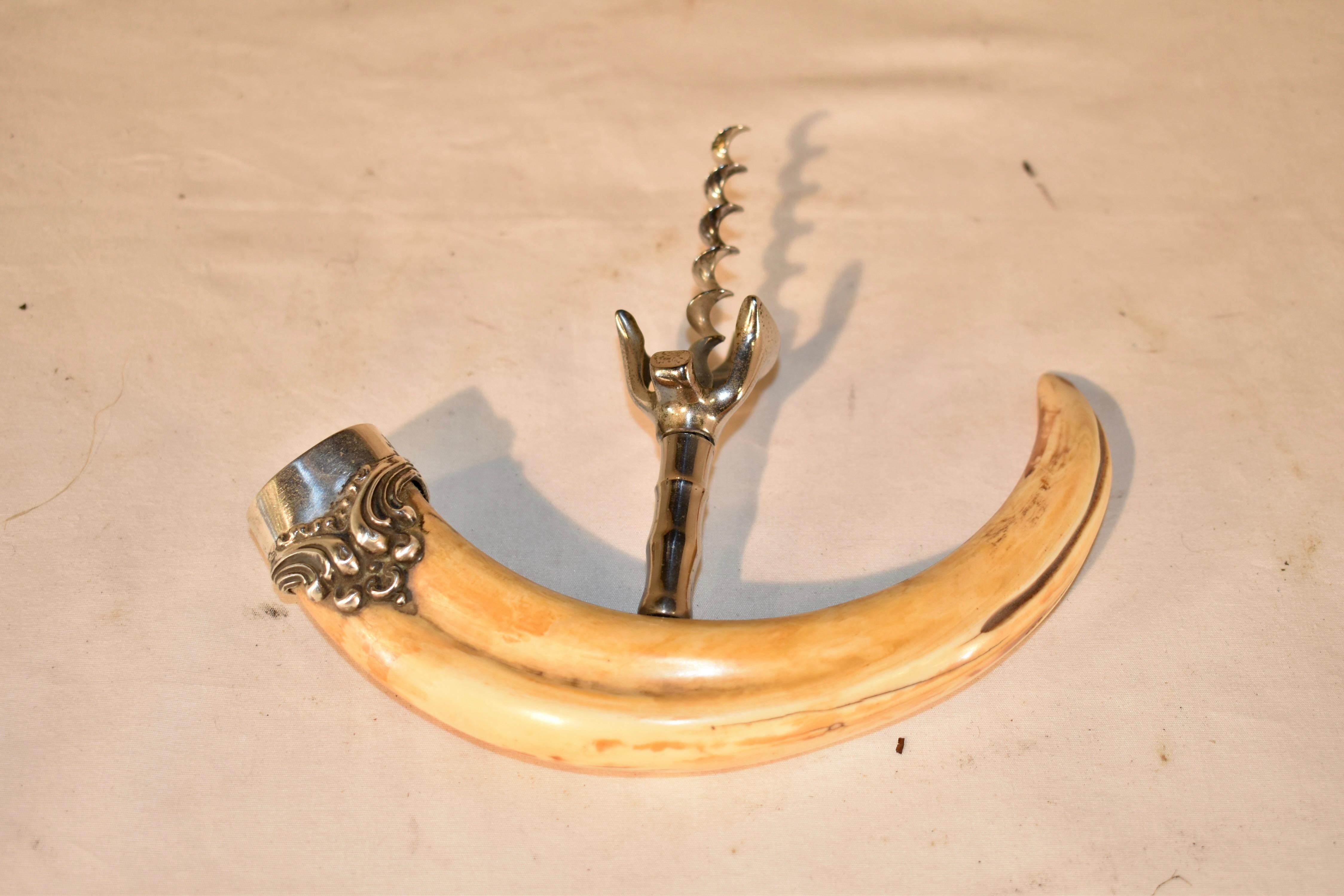Late 19th century boar's tusk corkscrew with sterling silver end cap.  This is a beautiful piece and would be a wonderful addition to any dining room or bar.  Cannot be shipped outside of the United States.