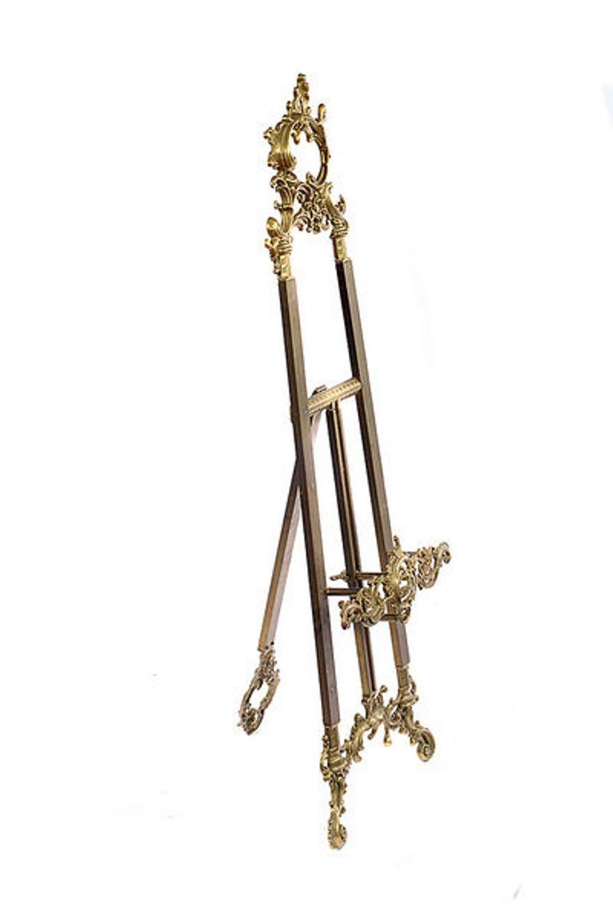 A late 19th century brass gallery easel stand,
The ornate Rococo style top and height adjustable stand is raised on scroll legs.
The actual height of the easel as a whole remains the same only the stand on which the picture sits can be raised or