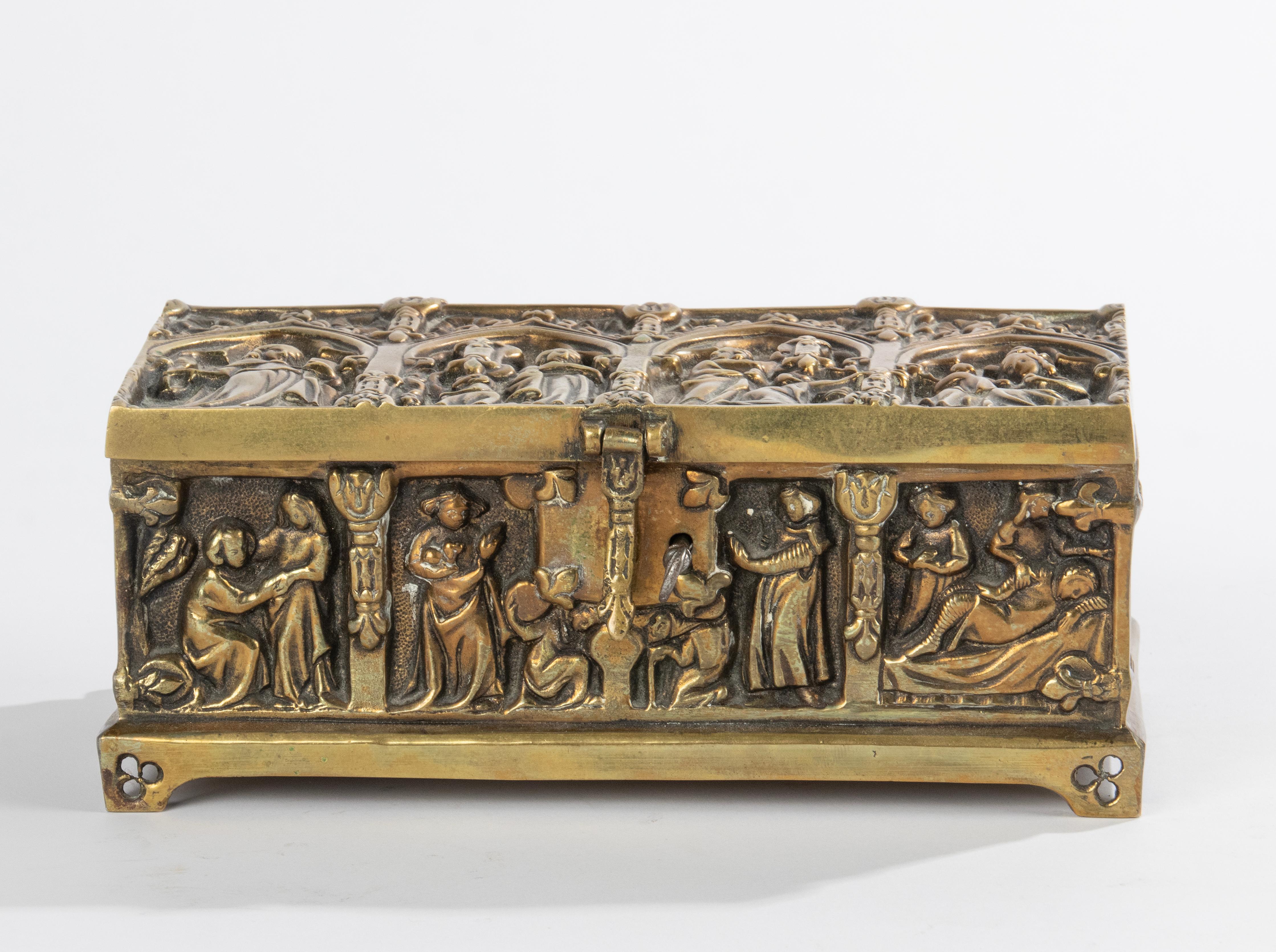 A beautiful bronze box in gothic style. Richly decorated with medieval figures and gothic ornaments such as cross flower and arches in the lid
The inside is covered with blue velvet. Beautiful colour and patina. 
With key. 
Dimensions: 9(h) x 21 x