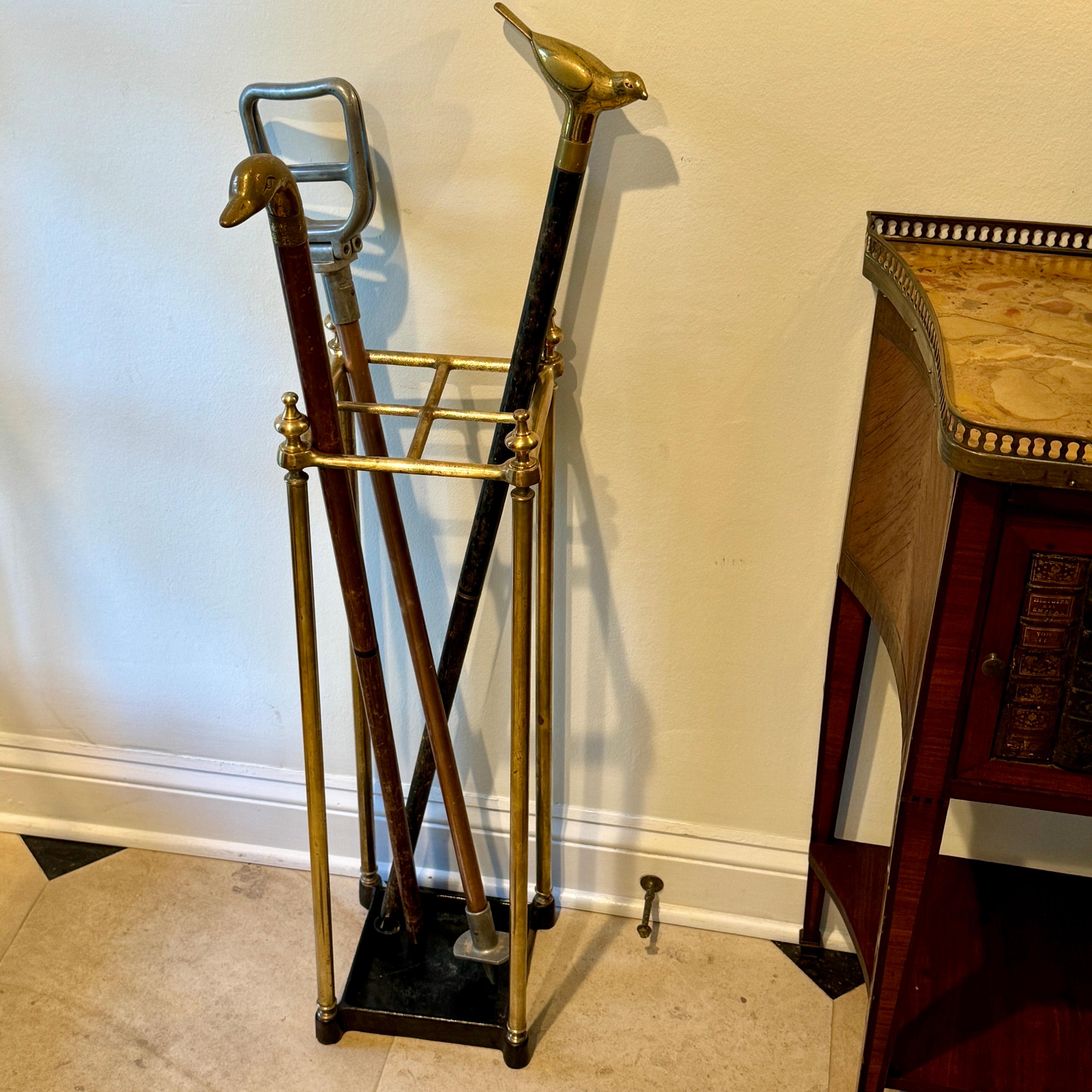 English Brass Umbrella or Cane Stand, circa 1890's. This vintage umbrella stand or cane stand makes an essential addition to your entryway. Beautifully sculpted, it features an elegant classic frame with an attached drip tray, painted black, below