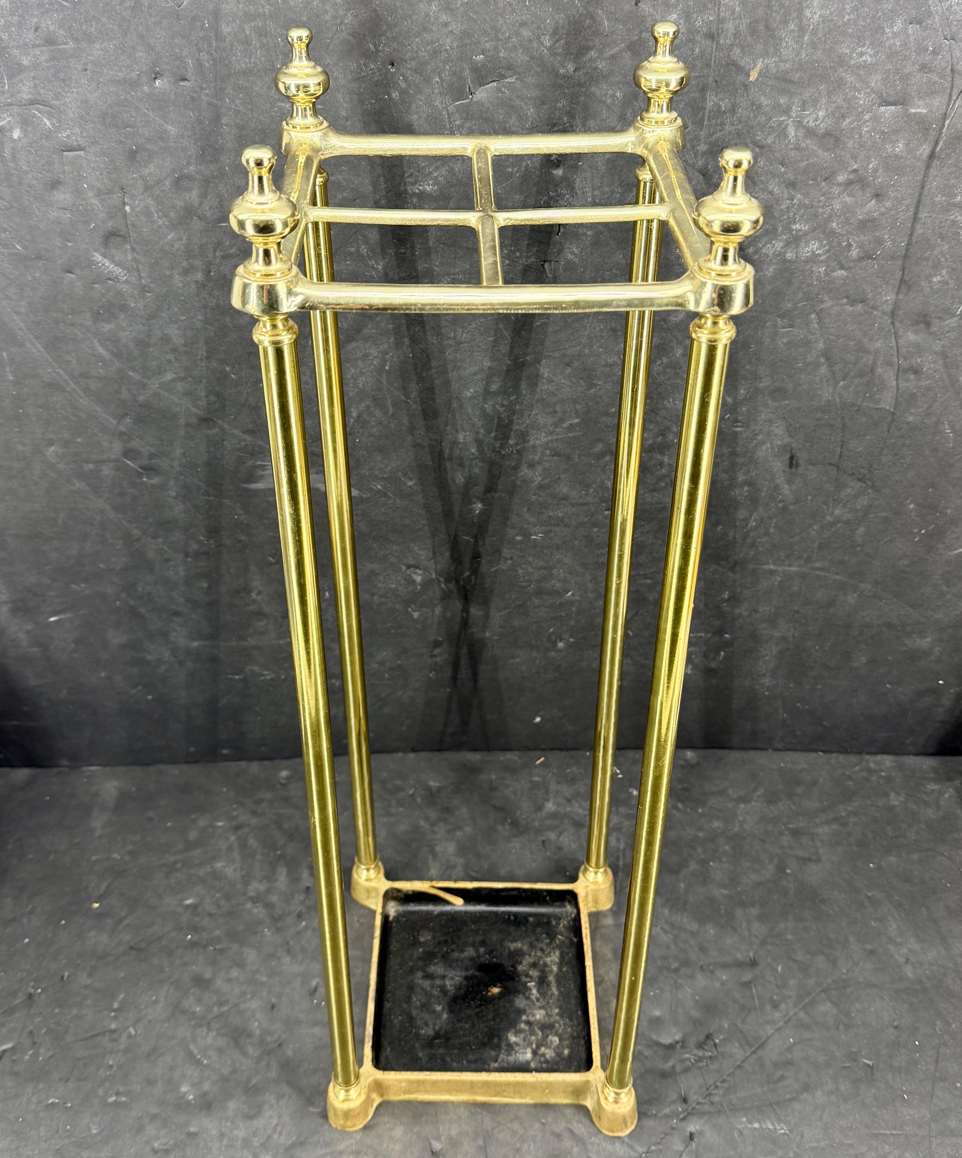 English Brass Umbrella or Cane Stand, circa 1890's. This vintage umbrella stand or cane stand makes an essential addition to your entryway. Beautifully sculpted, it features an elegant classic frame with an attached drip tray, painted black, below