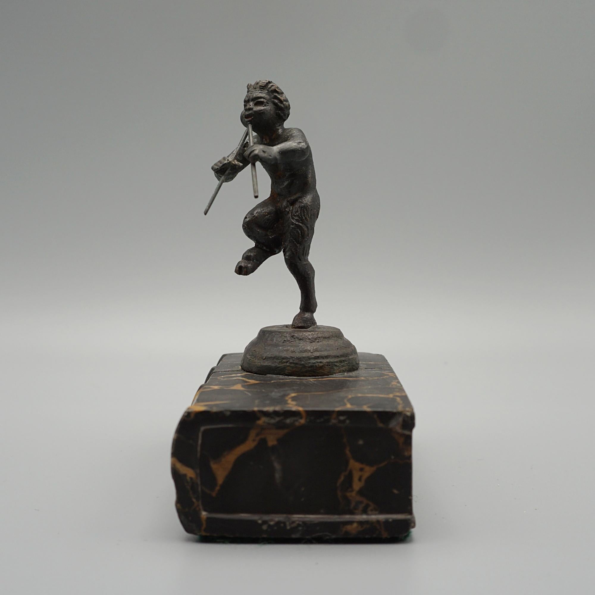 Eine Grand-Tour-Figur des pfeifenden Pan aus dem späten 19. Jahrhundert auf einem Marmorbuchsockel. Bronze und Marmor. 




