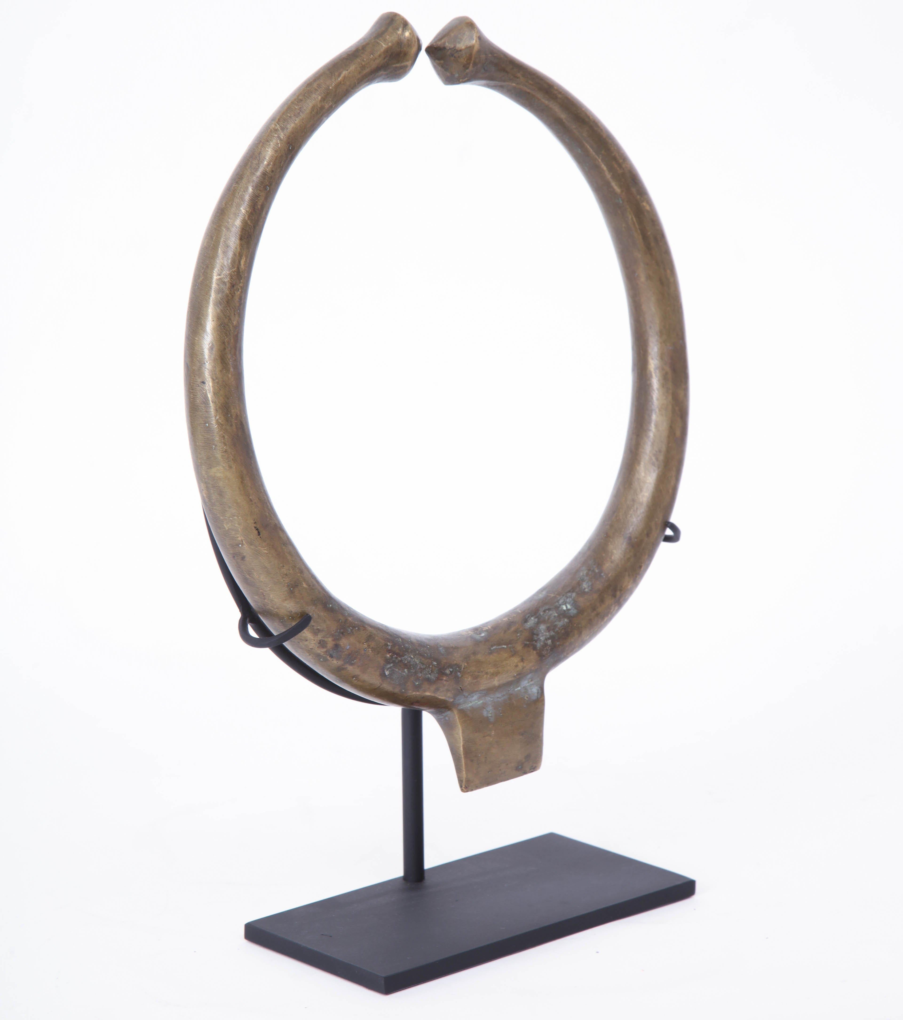 Late 19th century bronze torque necklace on stand.