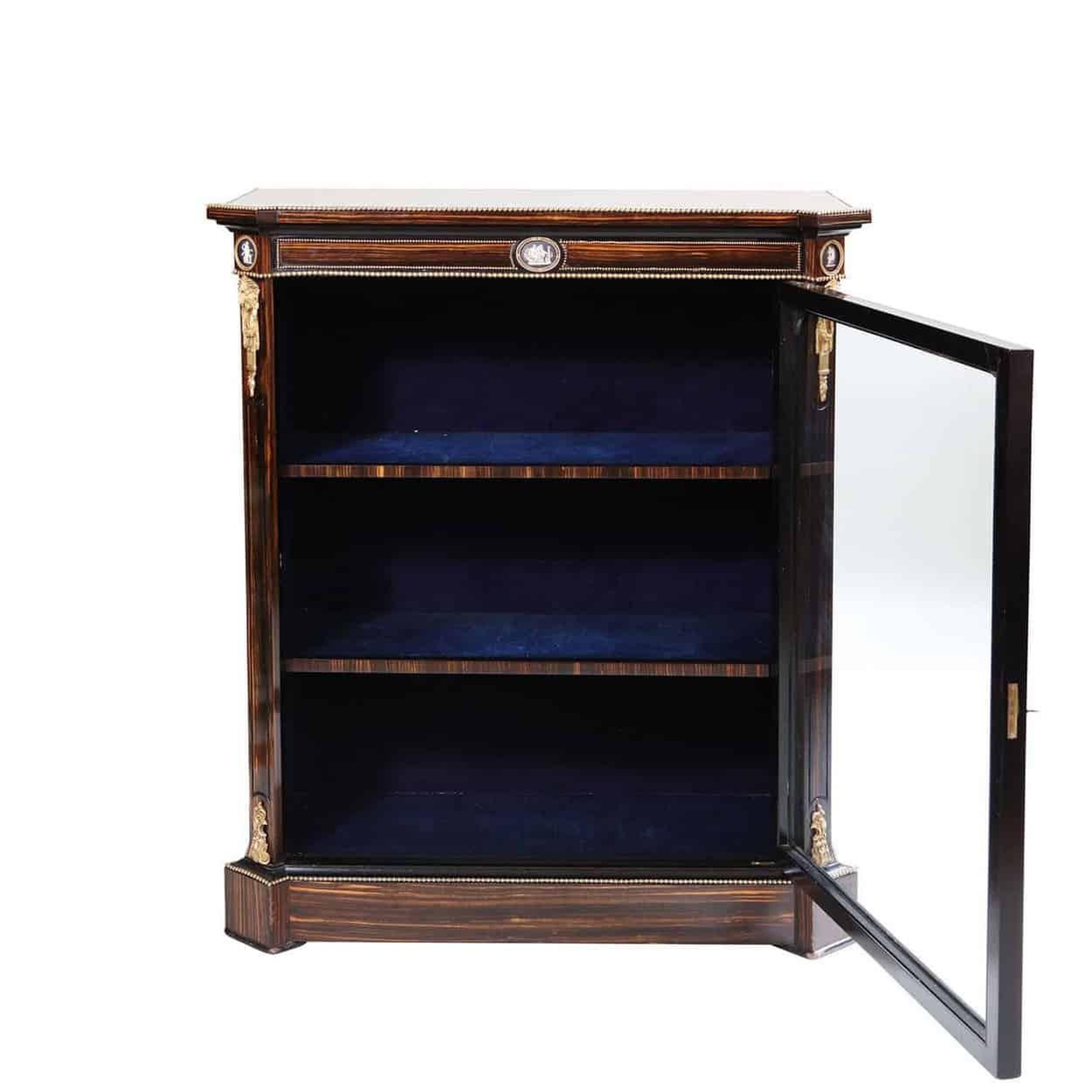 A fine late 19th century calamander wood vitrine cabinet, the top, and front veneered in calamander wood and the sides ebonised, the front and corners of the frieze inset with Pâte-sur-pâte plaques within gilt borders, the corners with classical
