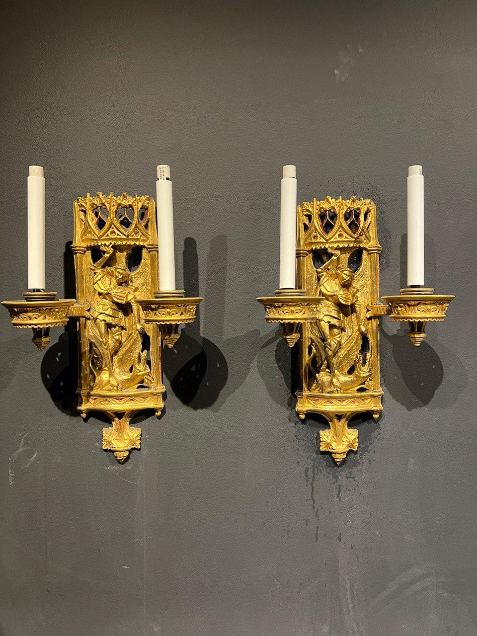 A pair of late 19th century gothic style Caldwell bronze sconces with St Michael motif 