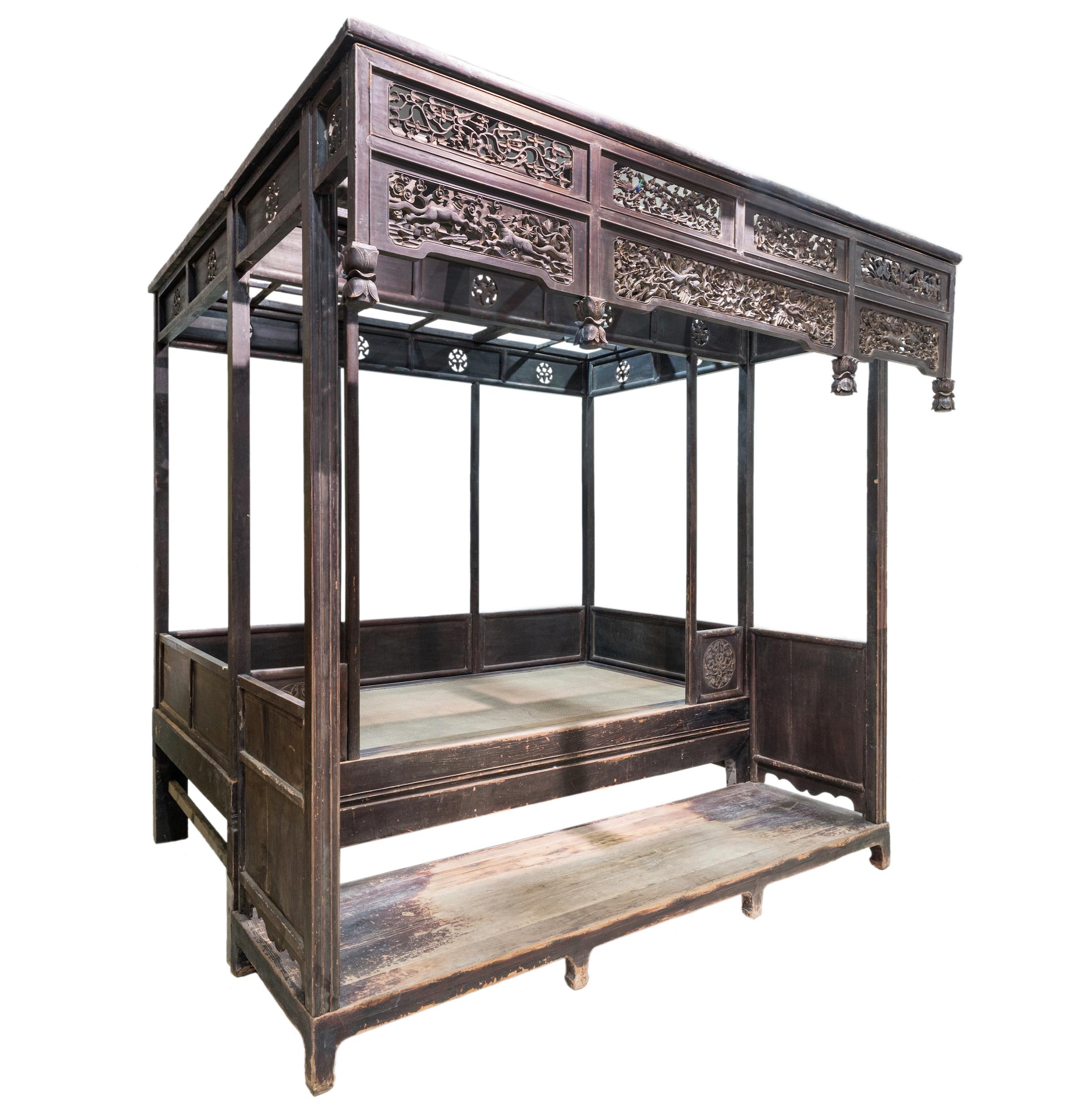 An antique canopy bed from Shanxi province made of Elm wood. This bed has all the attention focused on the front carvings while keeping a very simple and clean overall look. There is an extended area in front of the bed (around 67cm wide x H20cm)