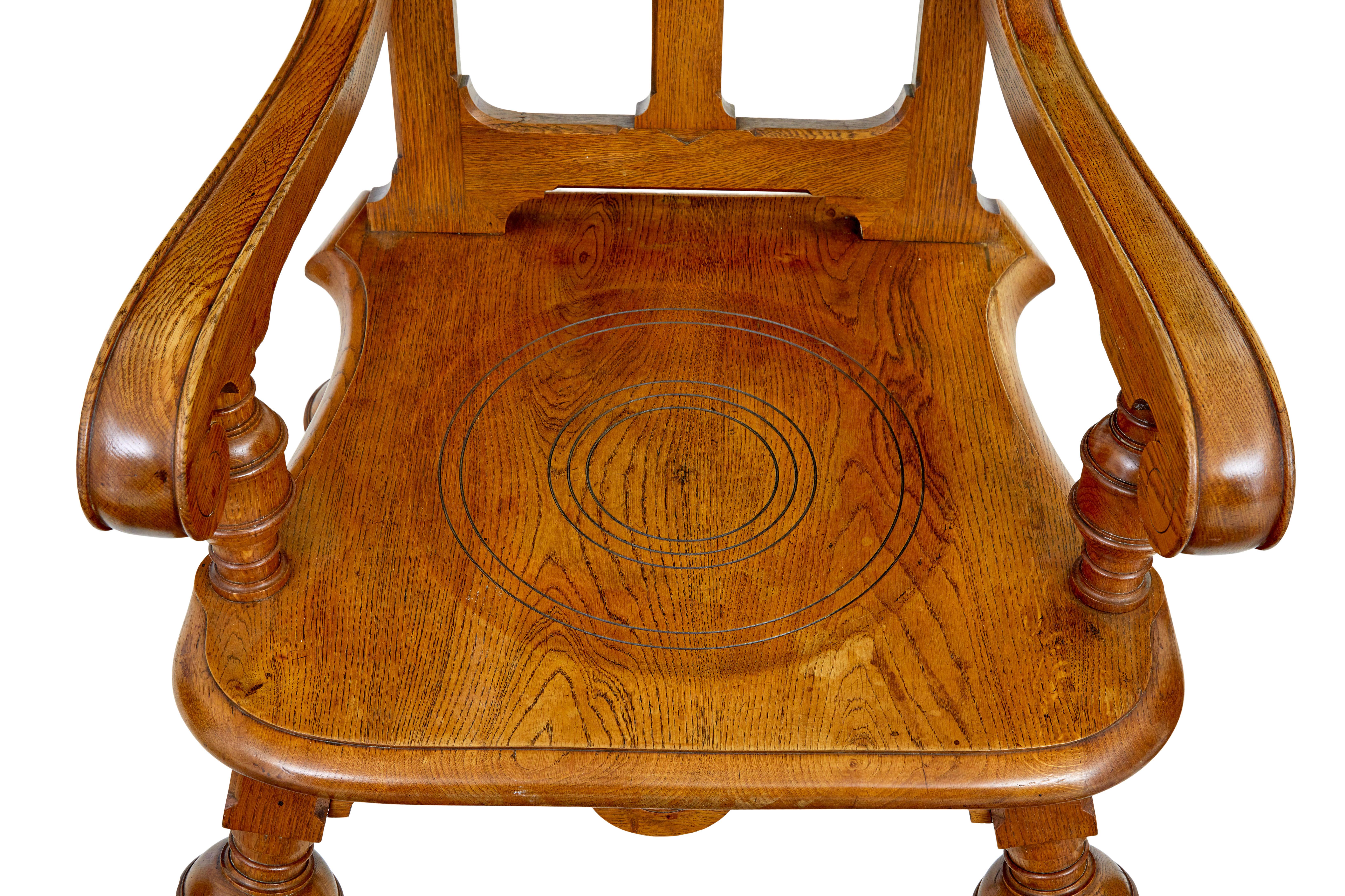 Late 19th century carved oak arts and crafts armchair circa 1890.

Shaped back rest with carved roundels and a central sunburst, link to the scrolled arms and turned supporting column.  Seat with circular pattern, and shaped for further