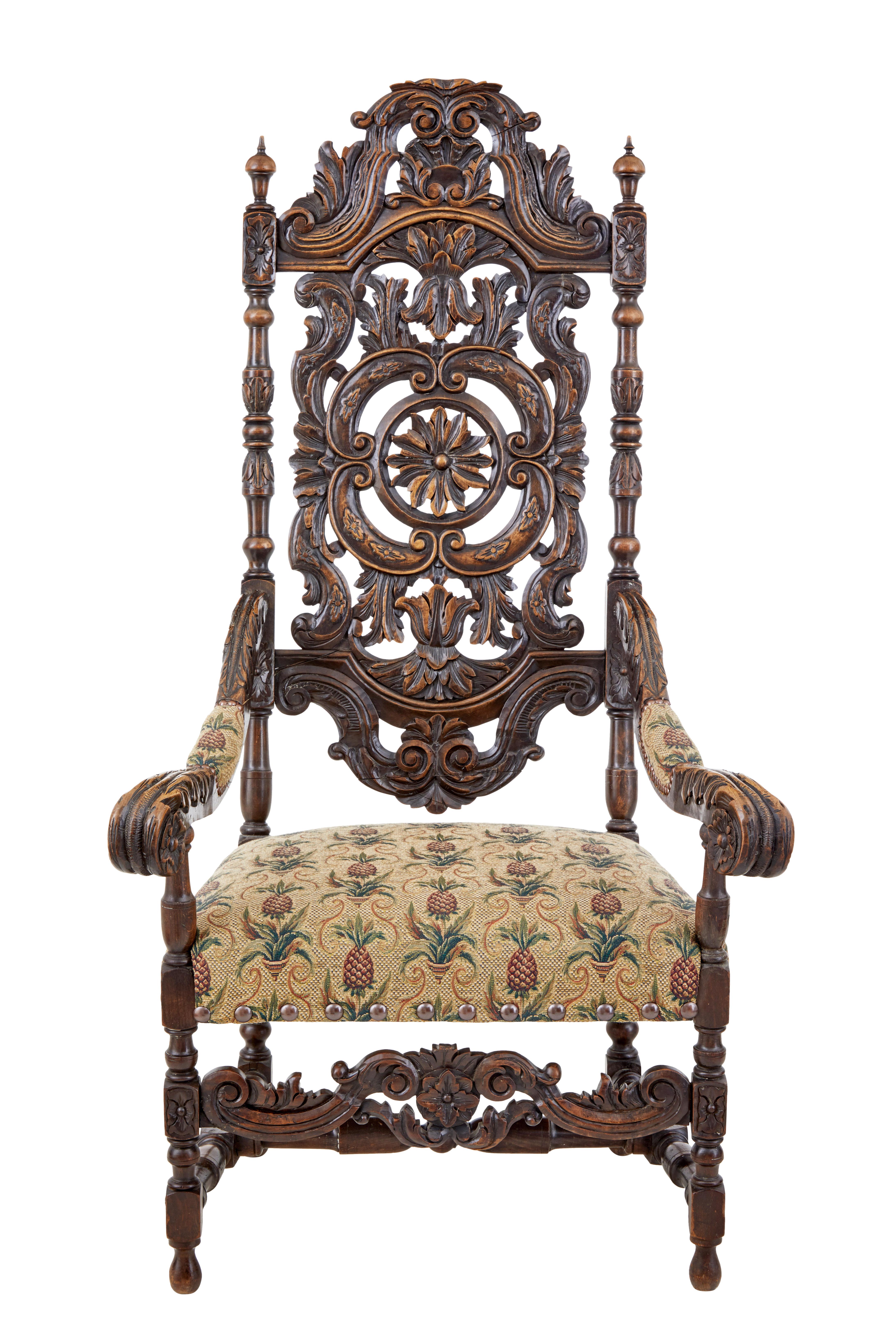 Profusely carved walnut armchair in the carolean taste, circa 1890.

Carved swags and a central sunburst are showcased on the backrest of this chair. Heavy carved scrolling arms leading down to the carved rail. Turned legs united by turned
