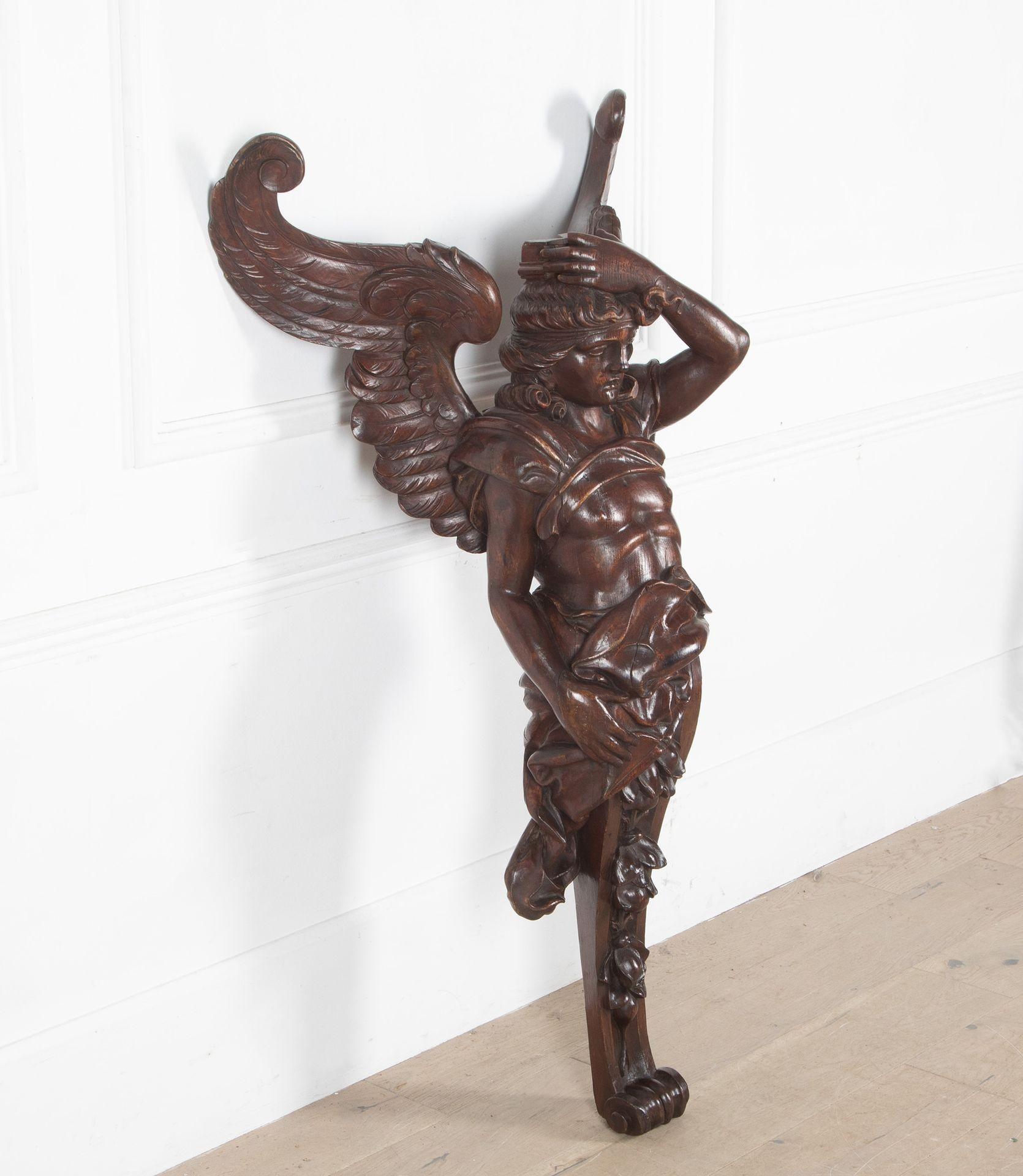 Englische geschnitzte Kiefernholzfigur des Erzengels Gabriel aus dem späten 19. Jahrhundert (1890). 
Das Gesicht, die Haare, der Körper, die Flügel, die Falten im Leinen und die Früchte und Blätter im unteren Teil sind fein ausgearbeitet und haben