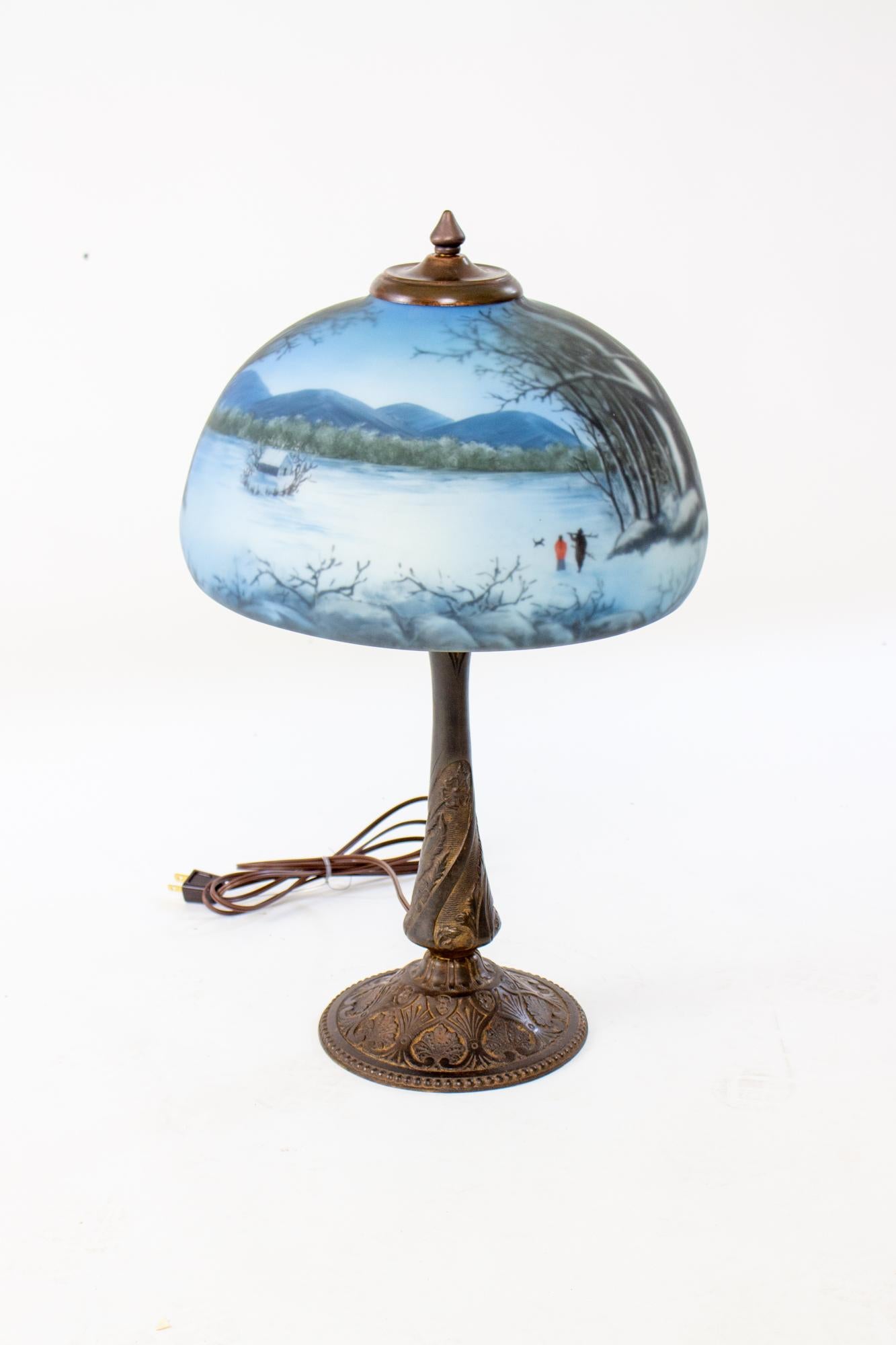 Late 19th Century cast iron table lamp with wintery blue reverse painted glass shade. Lamp is from the late 19th Century aesthetic period, just pre dating the art nouveau period and was originally lit with a gas flame. It was converted to