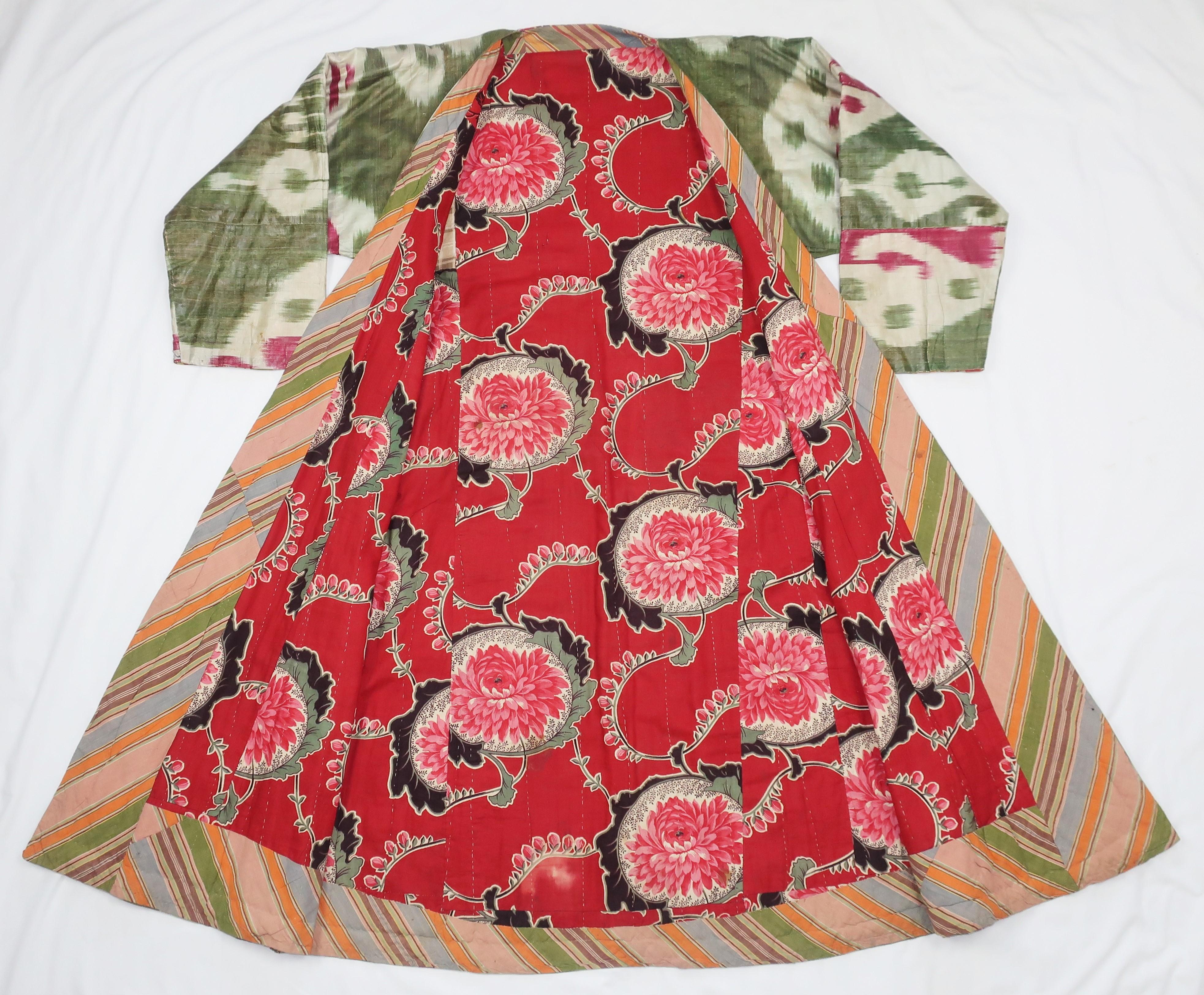 A beautiful late 19th Century silk woman's robe from the Fergana Valley region of Uzbekistan, Central Asia.  The robe is in a traditional silk Ikat pattern displaying shades of green and magenta.  It is lined in a Russian cotton red floral with