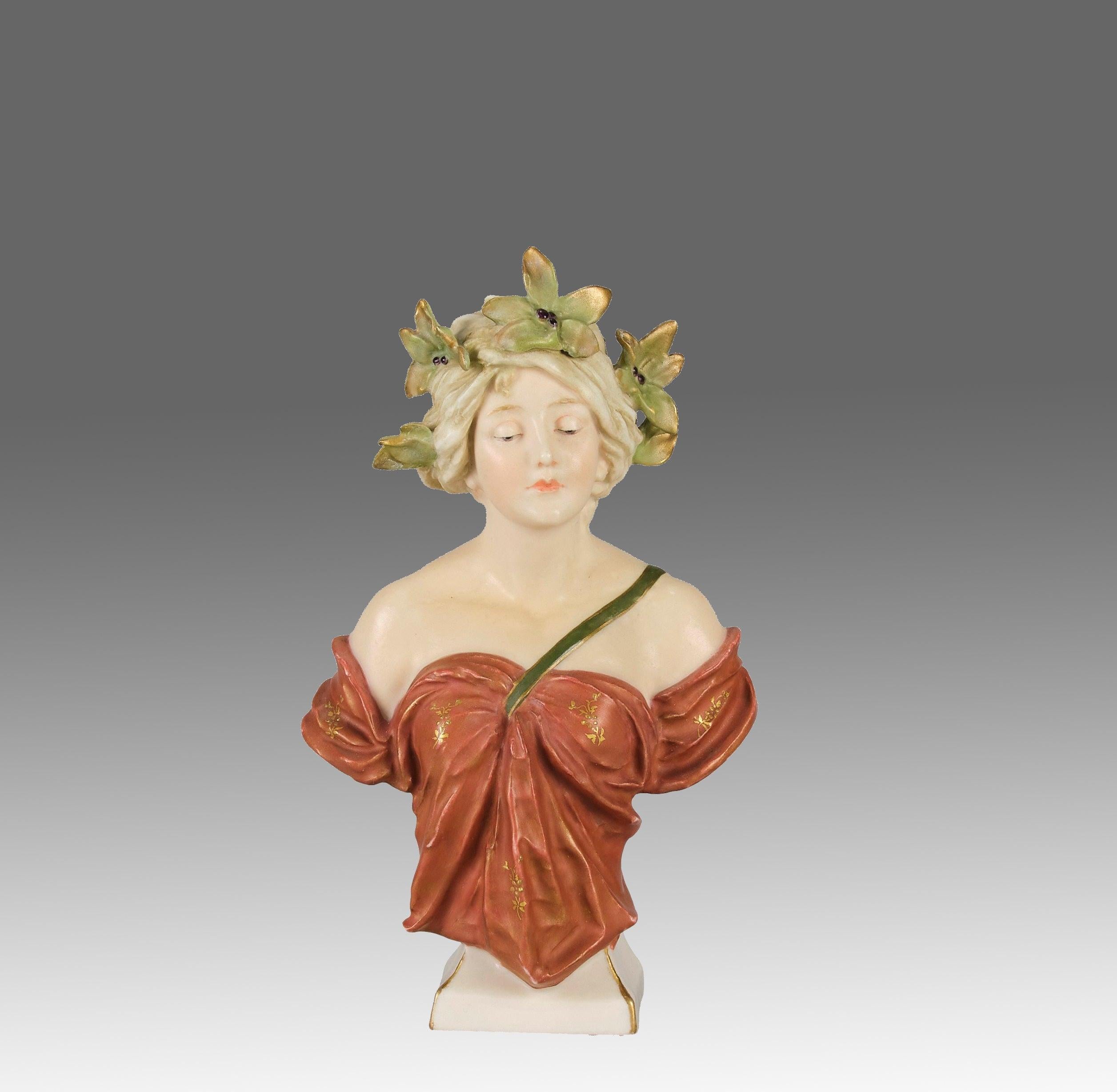 Magnifique buste Art nouveau en céramique de la fin du XIXe siècle, dans des tons de vellum avec des reflets dorés, représentant une jolie jeune fille Art nouveau portant une coiffe florale. Les couleurs et les détails sont excellents, et le cachet