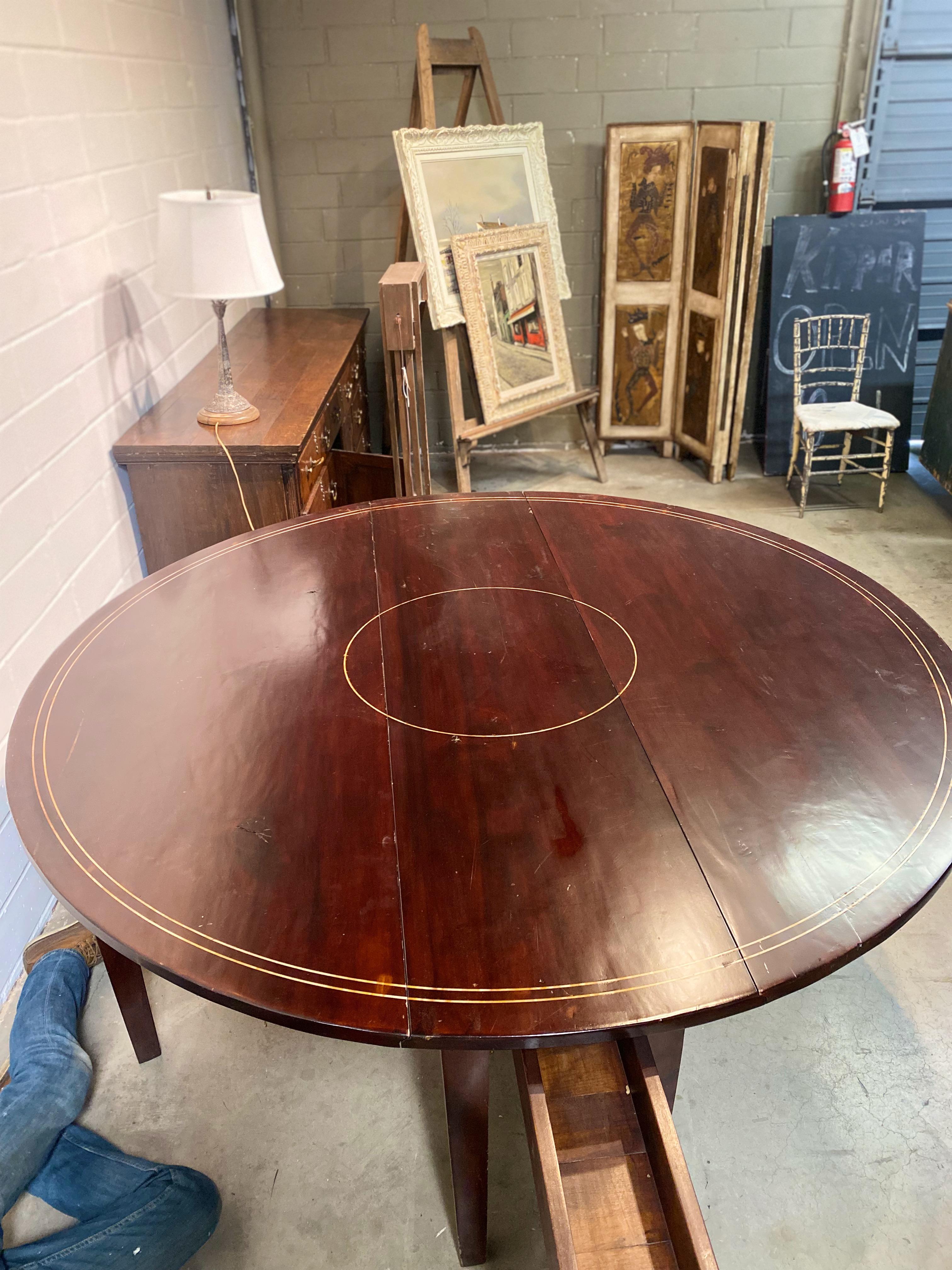 A stunning late 19th century Cherry Mahogany drop-leaf table that was previously used as a tasting table in a wine cellar. This table boasts a unique acrylic inlay on the top, adding a touch of elegance to its already beautiful design. The table is