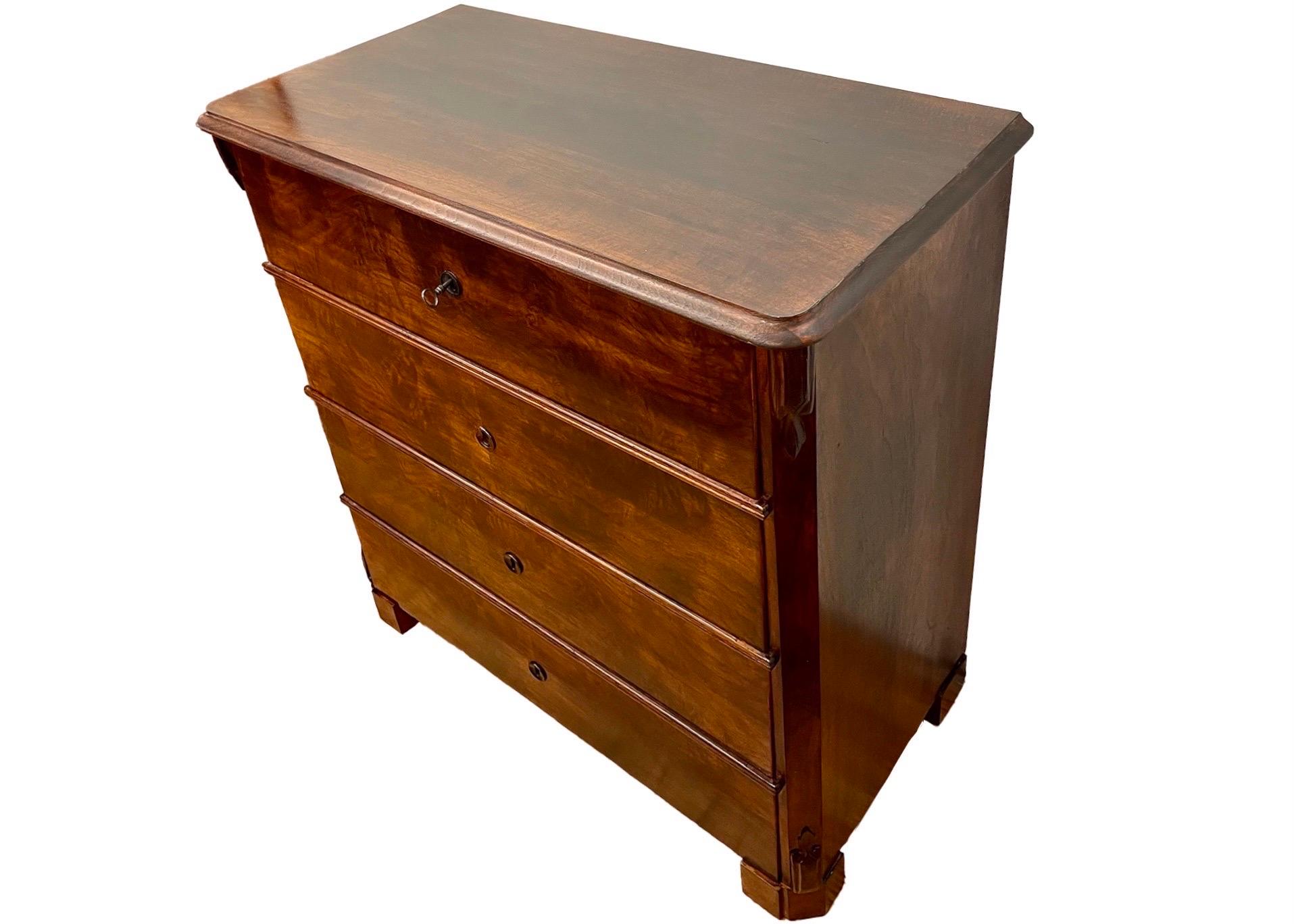 A beautiful and fully functioning dark wood chest of drawers. Book matched veneers adorn the visible faces, and the hand hewn carpentry is visible in the back panel. The drawers slide smoothly and all four locks open with the same original key.