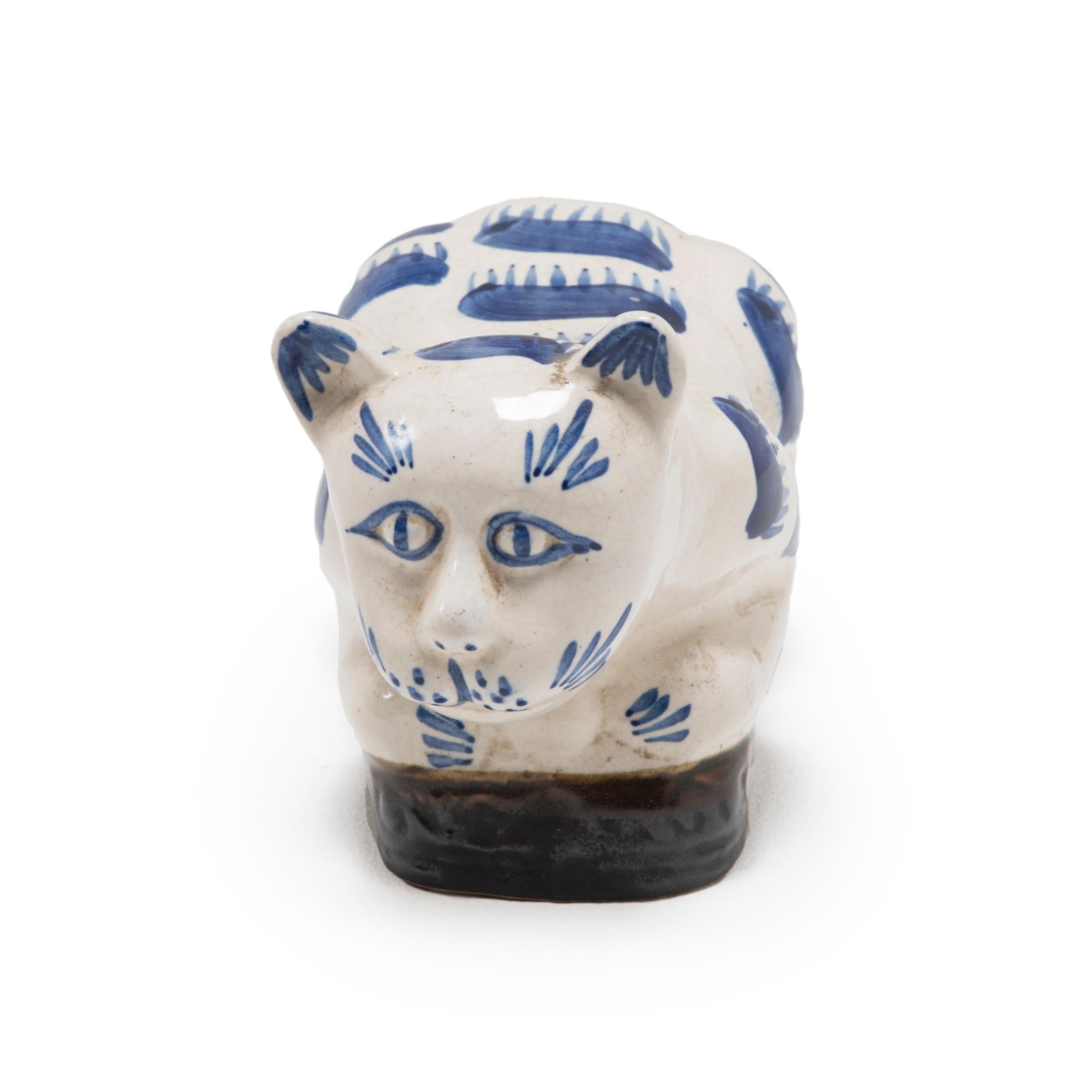 To keep her elaborate hairstyle intact while sleeping, a well-to-do Qing-dynasty woman once used this ceramic headrest as a pillow. The headrest is shaped as a crouching house cat, with whiskers and fur playfully painted in the blue-and-white style.