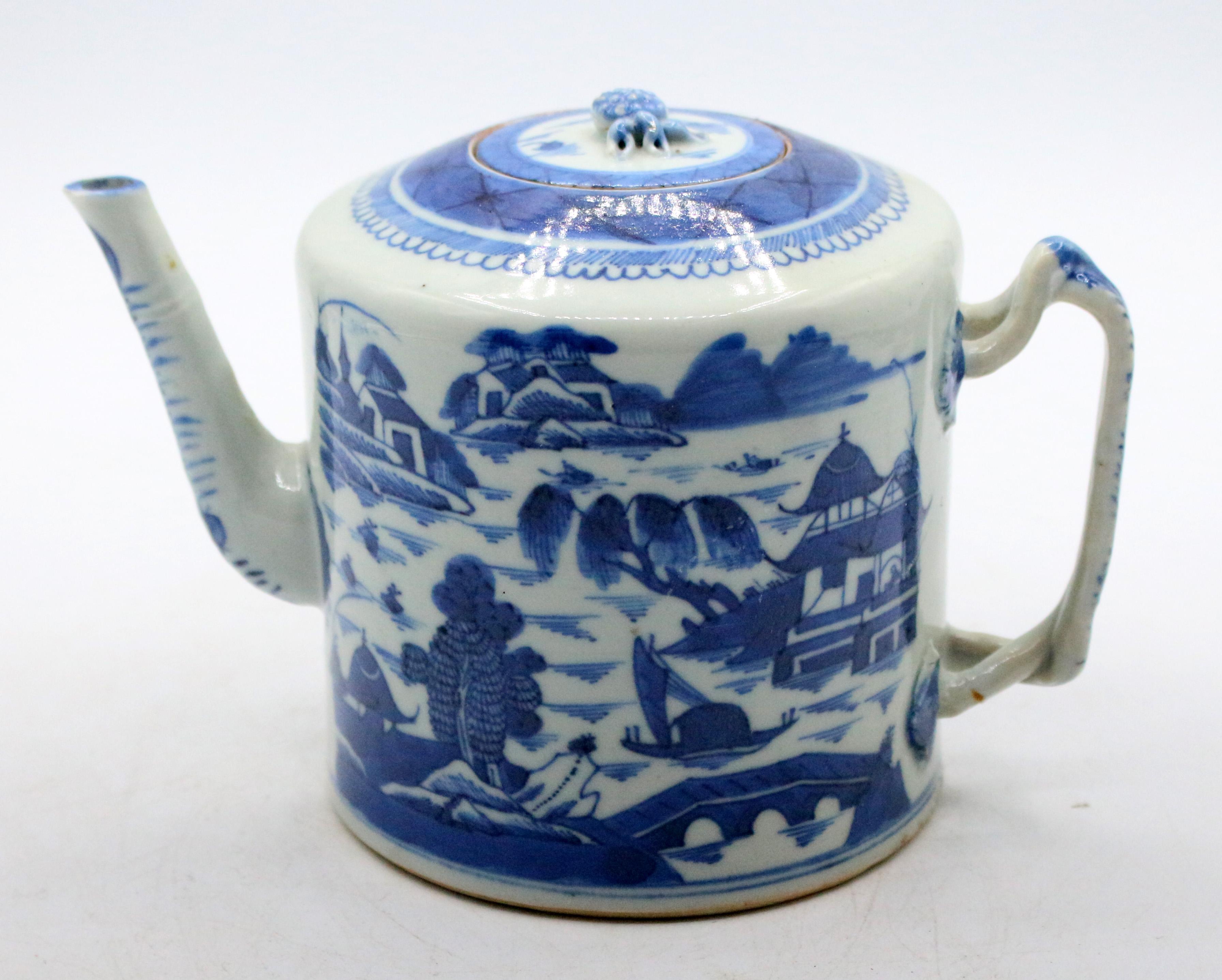 Late 19th century Blue Canton porcelain tea pot, Chinese. With double twined handle & pineapple finial. Tea house lake scenes decoration. The handle construction distinguishes the later date of the piece. Spout chip, minor roughness on lid, firing