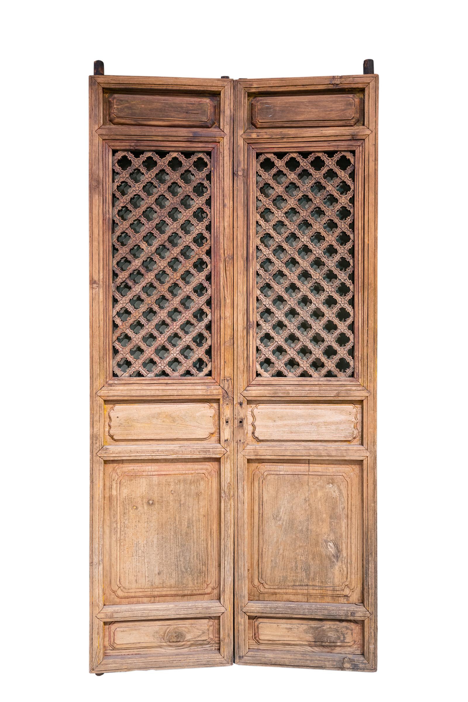 Late 19th century door panels from Shanxi province, China. These doors are simple in appearance but have many nice details; like the many layers of edging around the main lattice, and there are nice beadings around the plain raised panels in the top