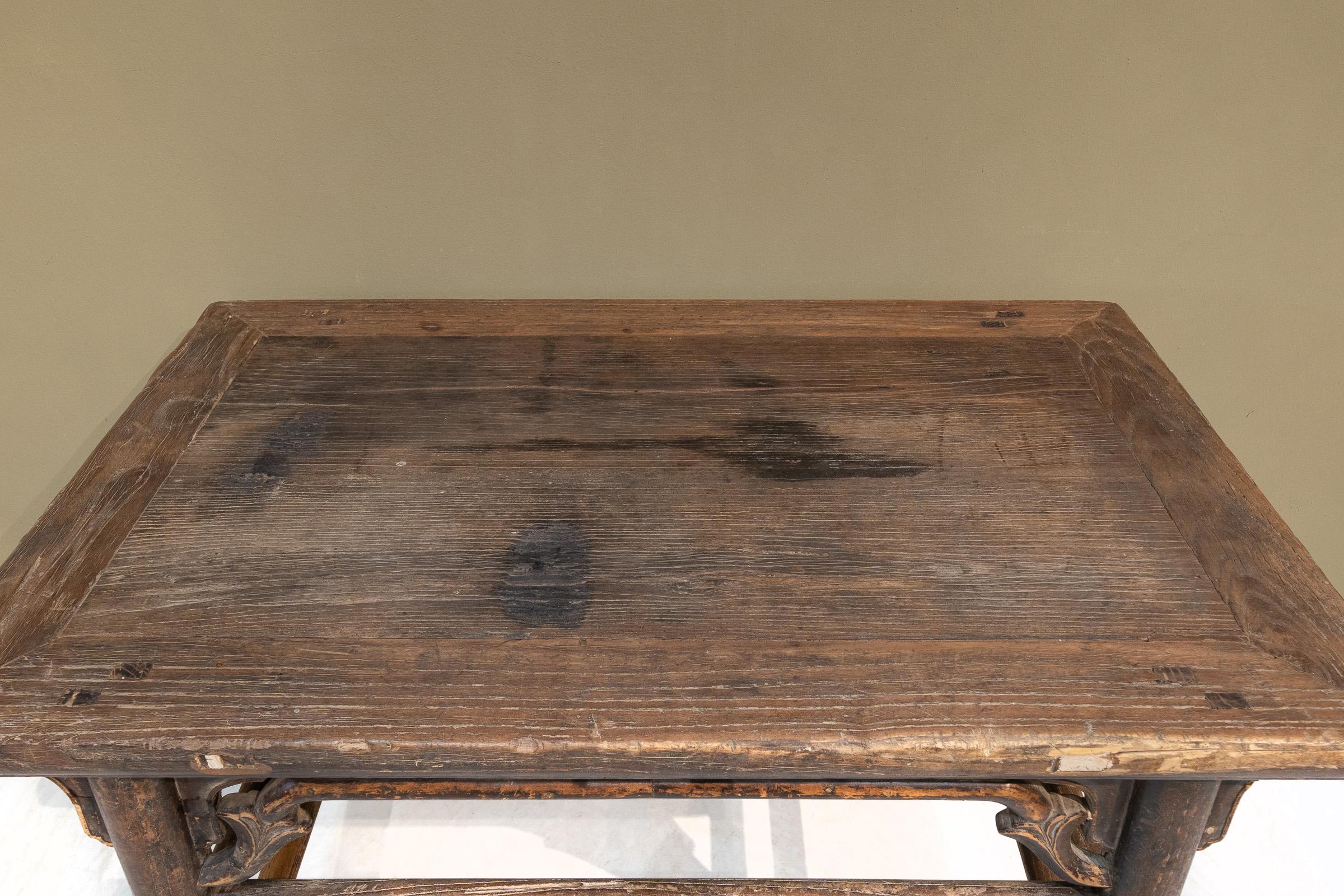 Dieser antike Weintisch aus Ulmenholz aus Shanxi mit doppelten Bahren an den Seiten hat ausgezeichnete Proportionen und eine hervorragende Patina. Die Buckelträger auf der Vorder- und Rückseite sind elegant geschwungen und auch die Schürzen haben