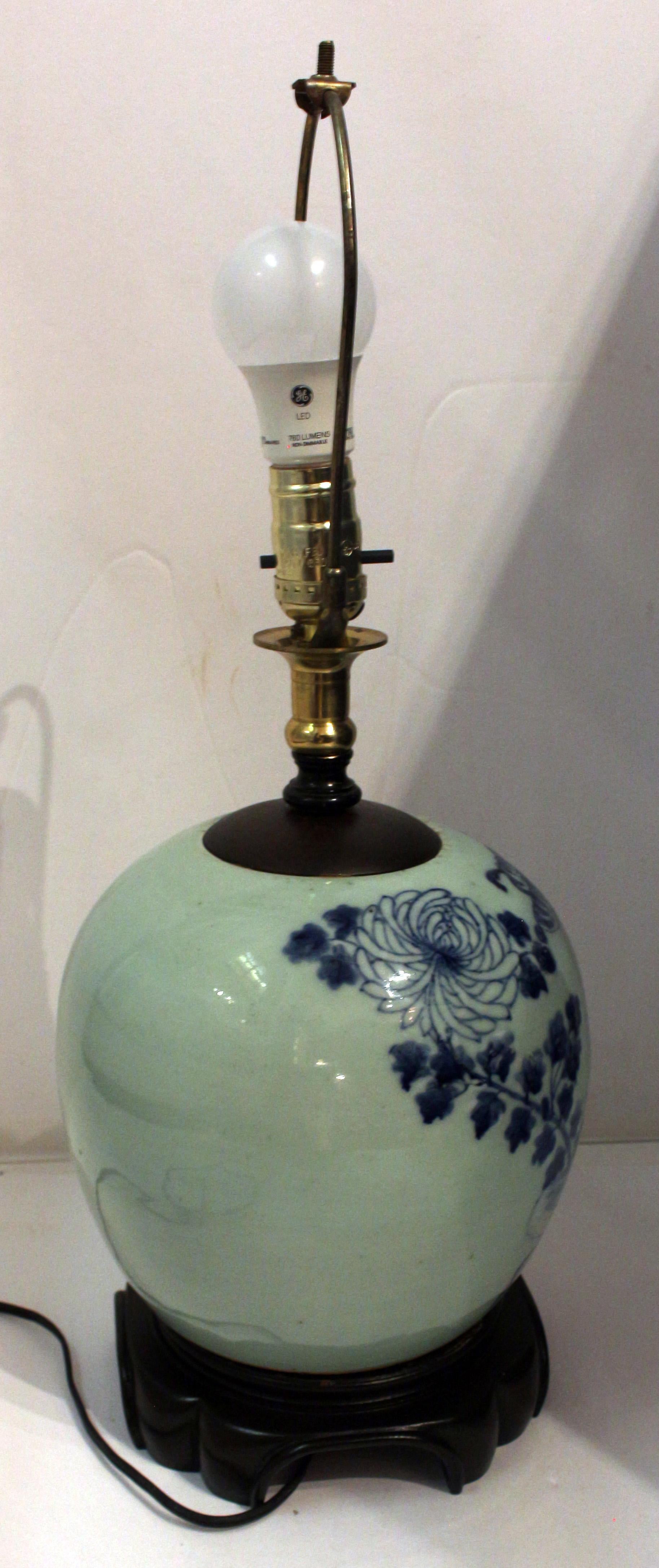 Late 19th century ginger jar now mounted as a lamp, Chinese. Qing Dynasty; blue & white on celadon. Fine carved base. Moth & butterfly among large chrysanthemums.
16.5