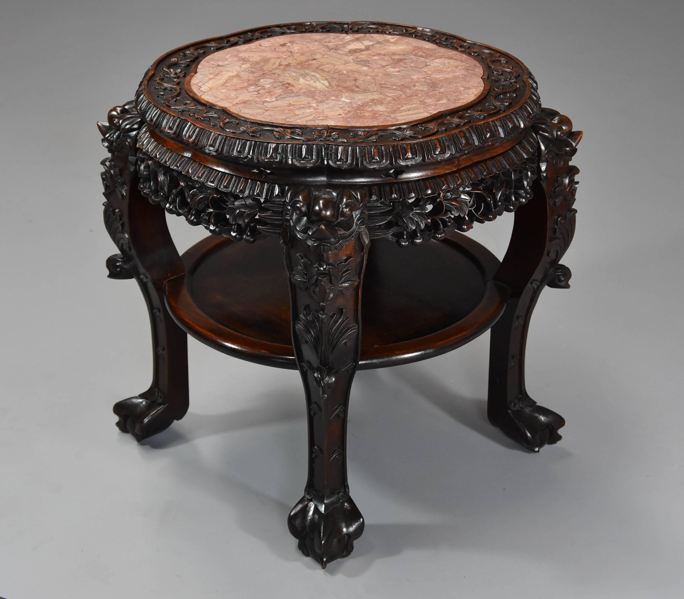 A late 19th century Chinese hardwood circular pot stand or low table with shaped marble inset top. 

This pot stand consists of a shaped Chinese rouge marble top, this being recessed into the top surrounded by foliate and floral carved decoration