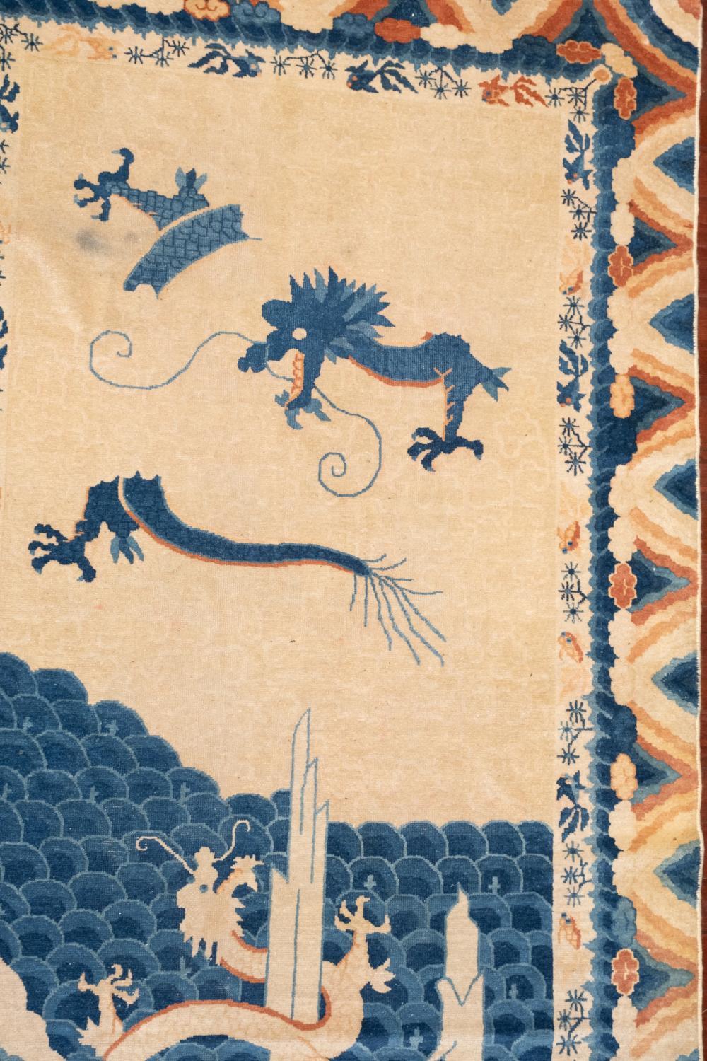 This late 19th century hand-knotted carpet features unique and vibrant Chinese Peking Dragon motifs throughout. Would make an excellent statement piece in a dressing room. 