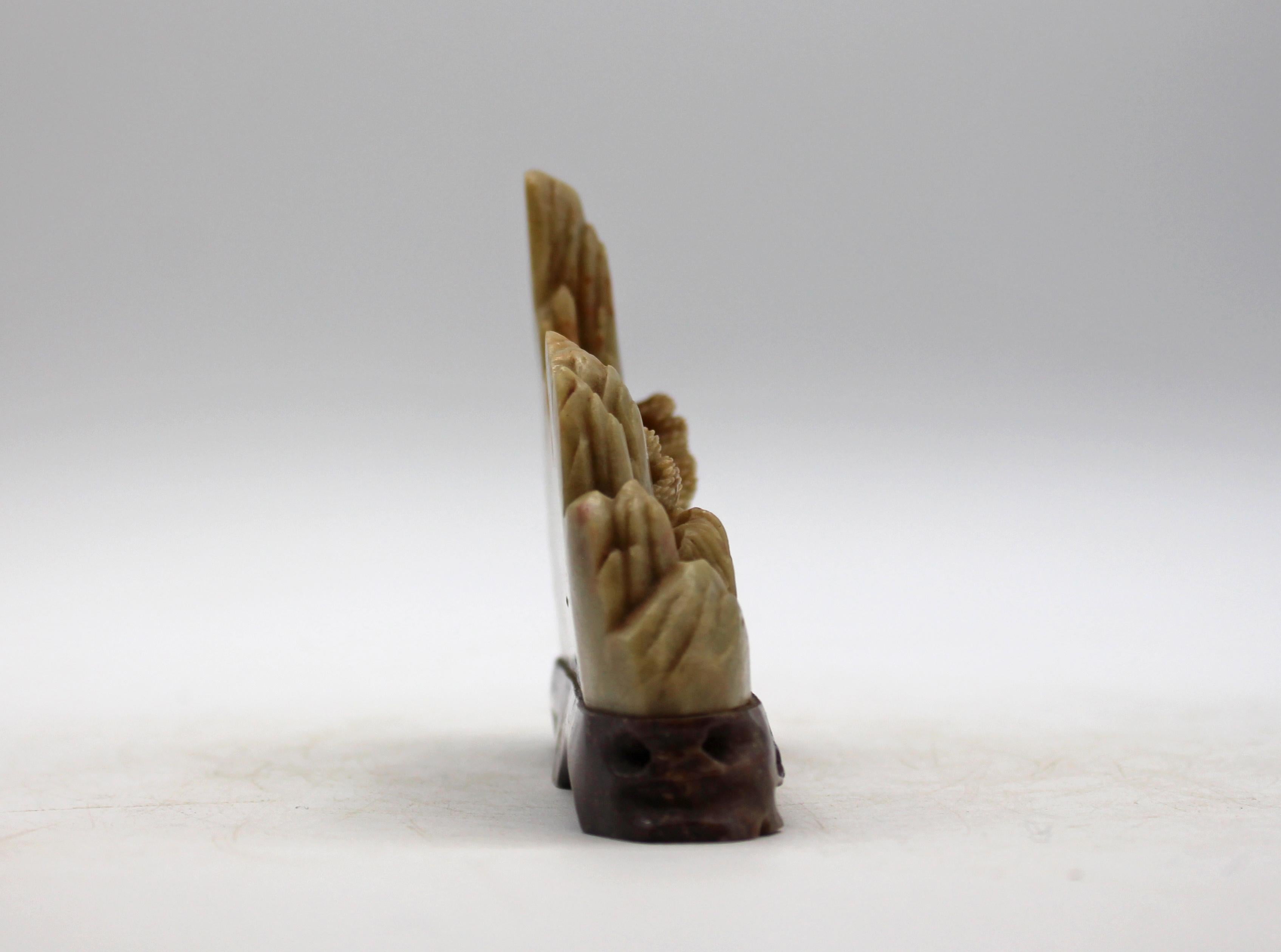 Poggiapennello da studioso intagliato in pietra Qingtian (pietra ollare) della fine del XIX secolo, cinese. Una scultura paesaggistica che raffigura case da tè tra alberi di pino in riva a un lago con montagne alle spalle. Colore a contrasto,
