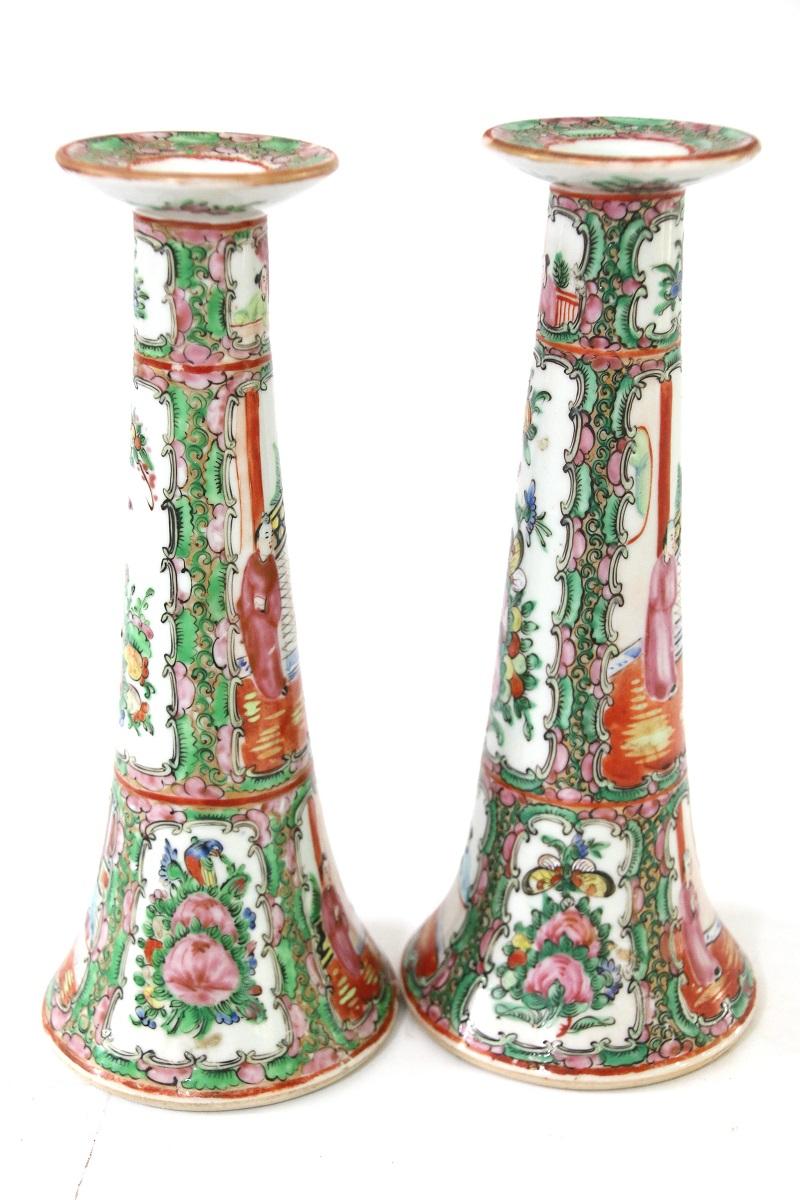 Late 19th century Chinese Rose Medallion near-pair of trumpet form candlesticks with panels of figures, flowers, and exotic birds. Candlesticks are almost identical.

Measures: 10 ¼” H x 4 ¼” W (at base).
 